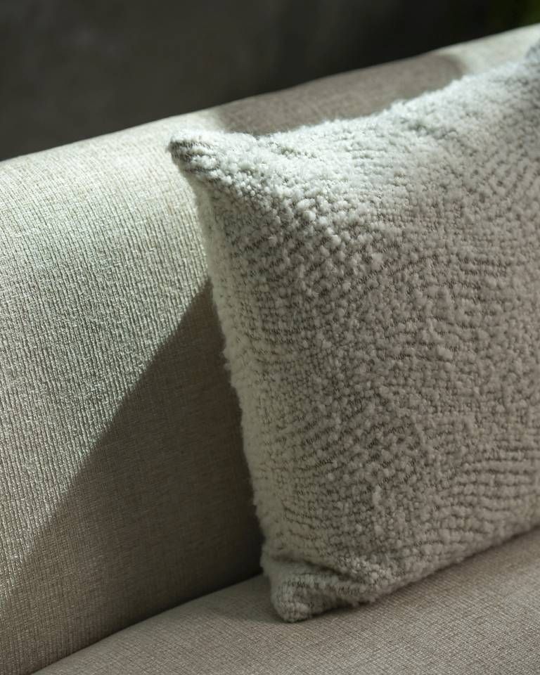 Nahaufnahme des Ethnicraft Wave Cushion Kissens (60x40 cm) in Off-White auf einem Sofa, Texturdetails sichtbar.