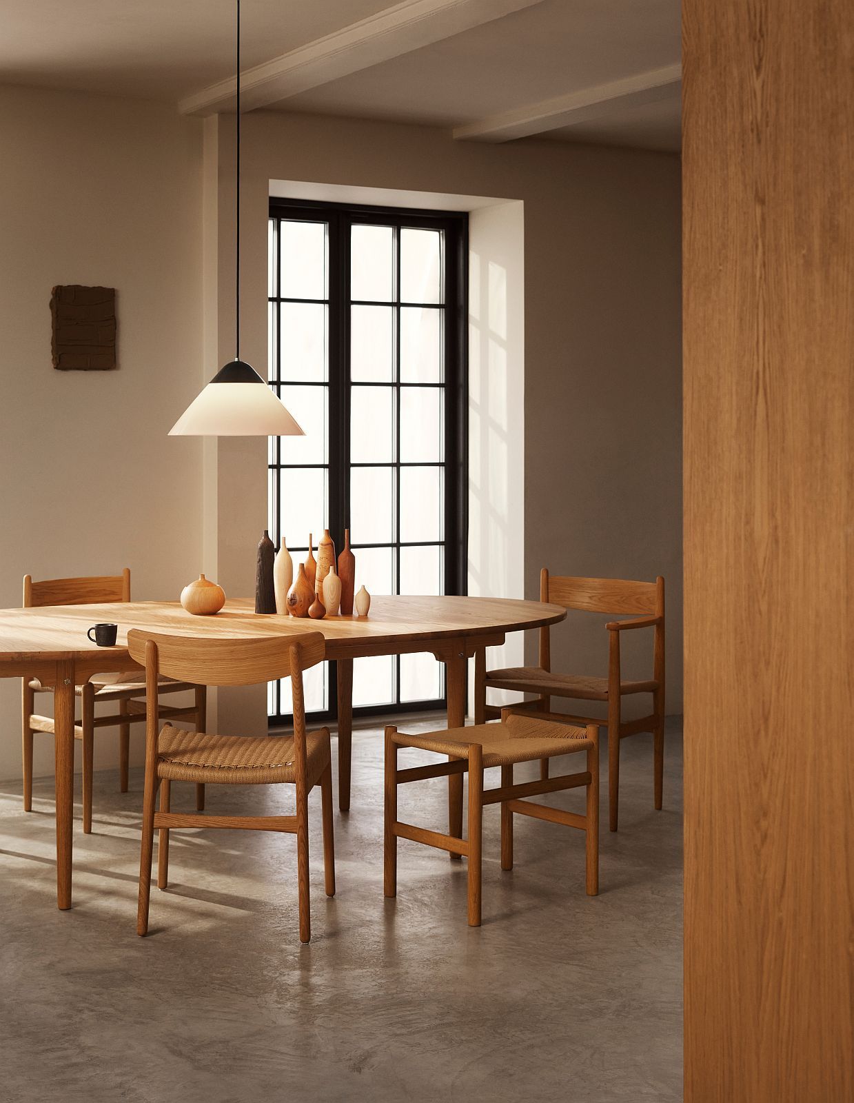 Helle HJW38 Opala Pendelleuchte von Carl Hansen & Søn über einem Esstisch mit Holzstühlen.