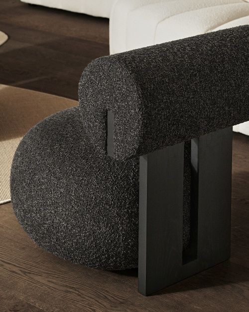 Detailaufnahme des Hippo Lounge Sessel NORR11 mit dunklem Bouclé-Stoff und schwarzen Holzbeinen.