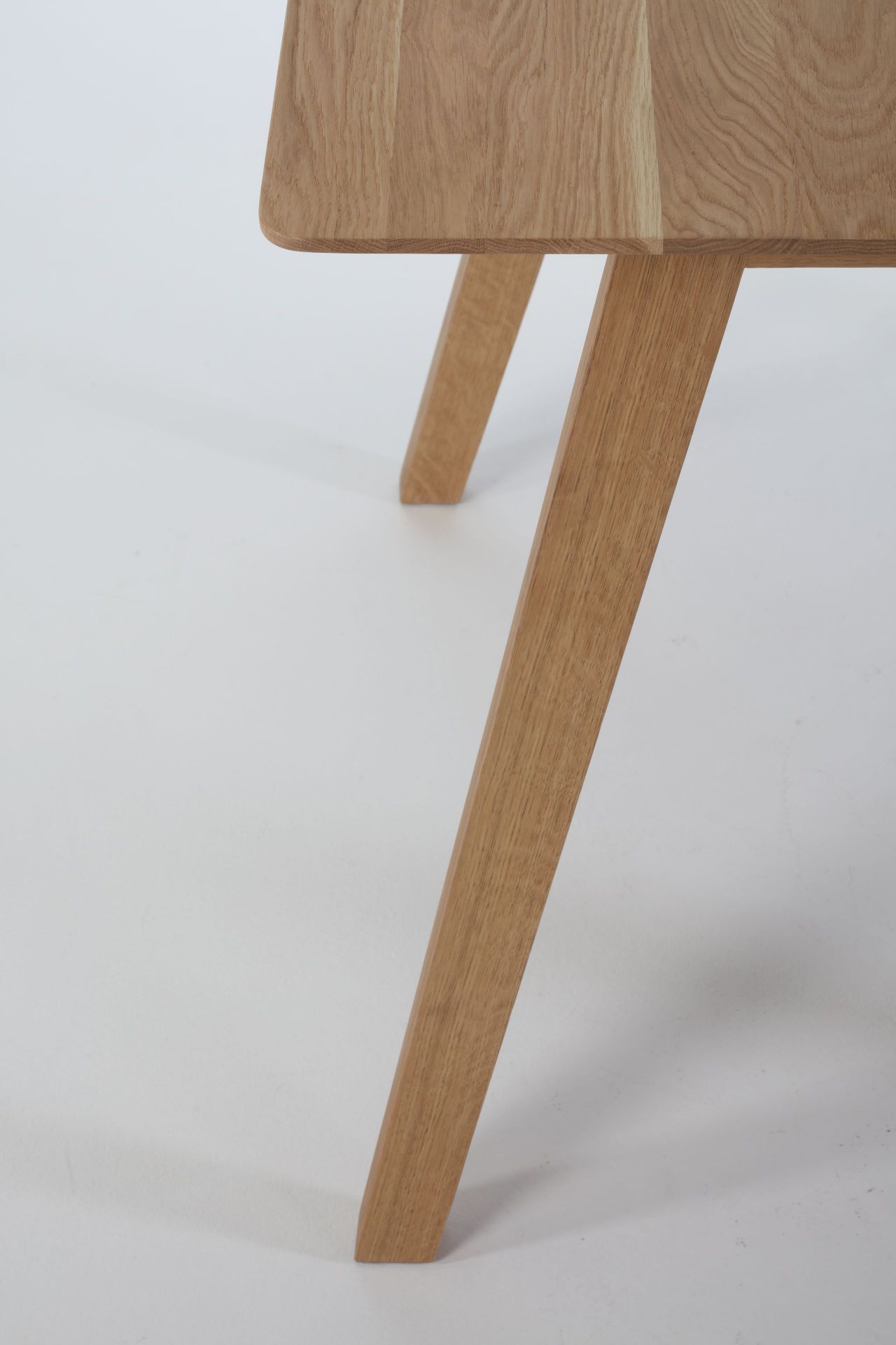 Detailaufnahme des Monk Tisches von Prostoria, Fokus auf die Tischplatte und die Tischbeine aus hellem Holz.
