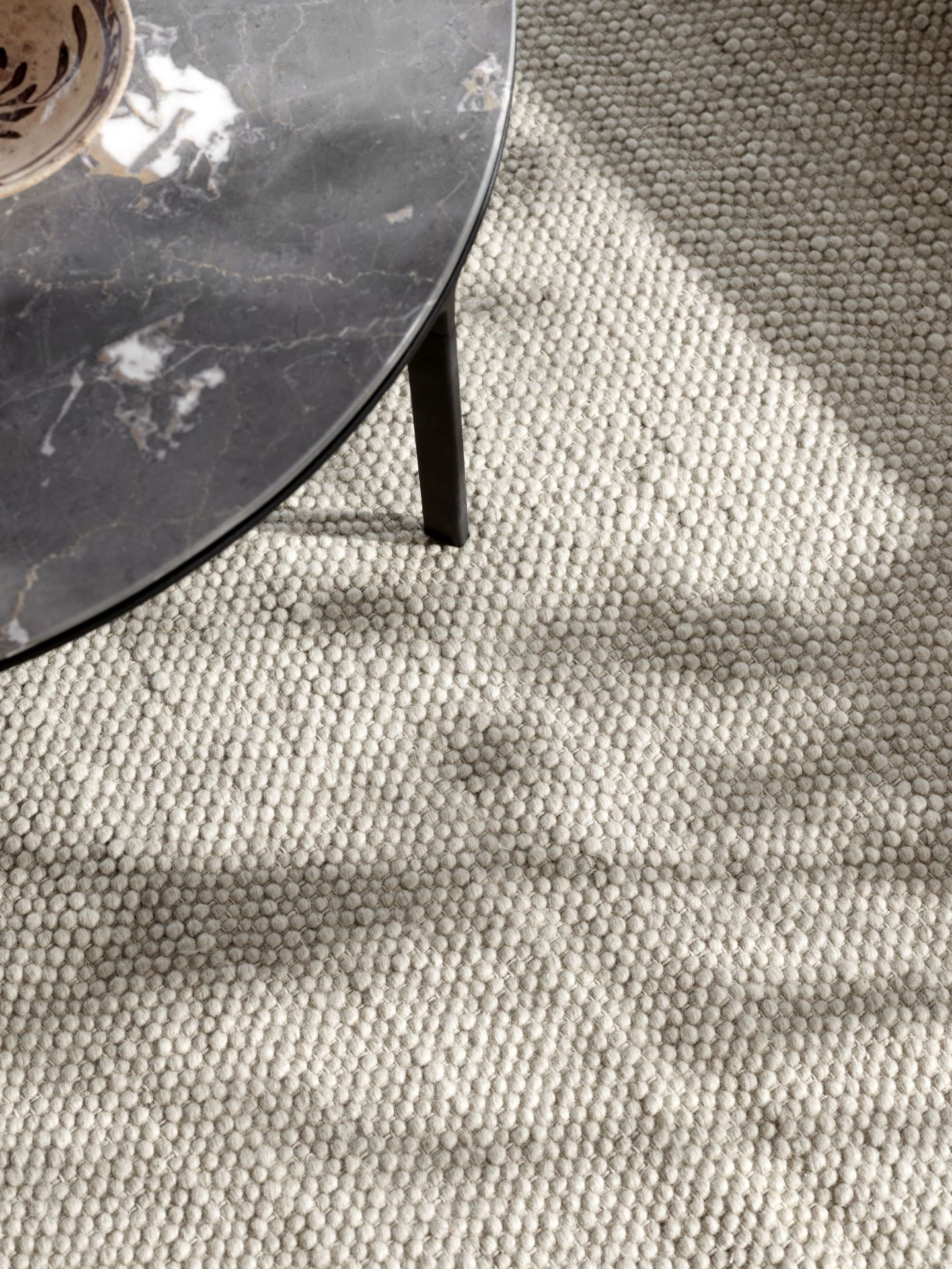 Detailaufnahme des Vipp  Wollteppichs in Beige, mit einer weichen, texturierten Oberfläche und einem modernen Design.
