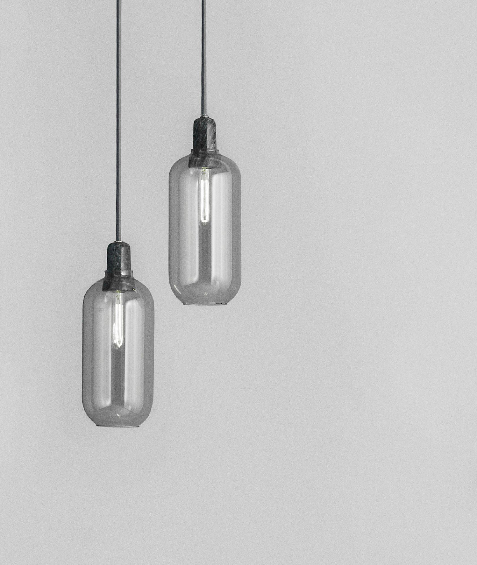 Zwei Amp Lamp Hängeleuchten von Normann Copenhagen in Rauchglas und Schwarz.