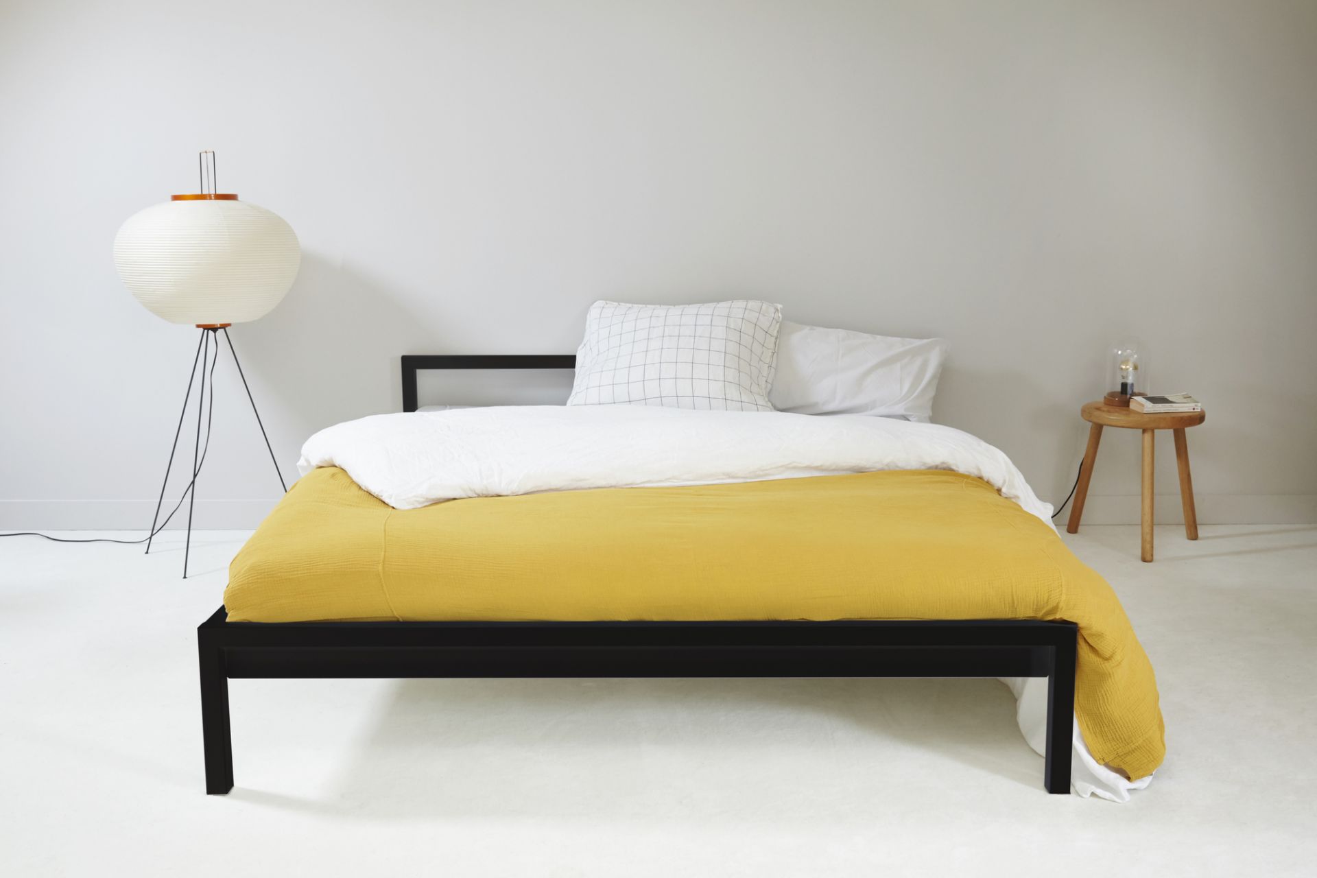 Schwarzes Hans Hansen Bettgestell aus Stahl, 160x200 cm, mit gelber Decke und Nachttischlampe. Modernes Schlafzimmer-Design.