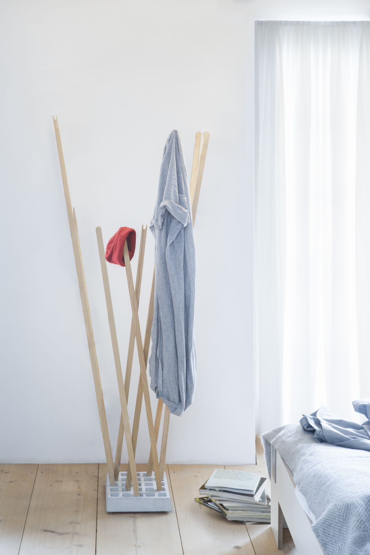 Helle minimalistische Schlafzimmereinrichtung mit Moormann Pin Coat Garderobe aus Holz mit Jacke und Mütze.