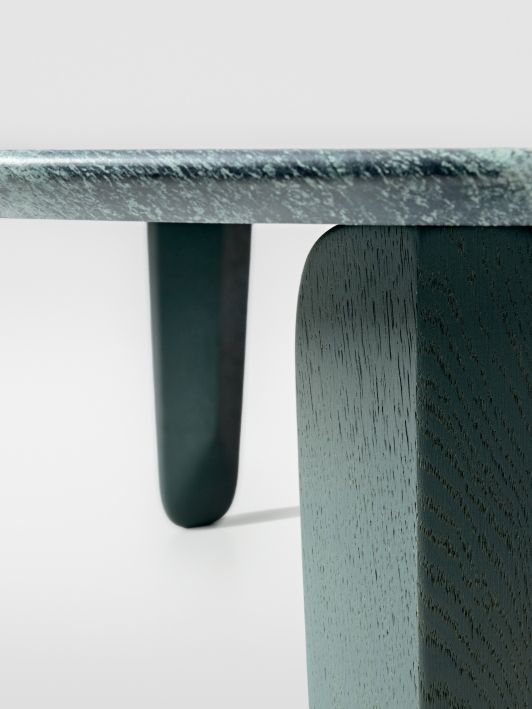 Detailaufnahme vom Kuyu Marble Couchtisch: Runde Marmorplatte und massive, farblich passende Holzbeine.
