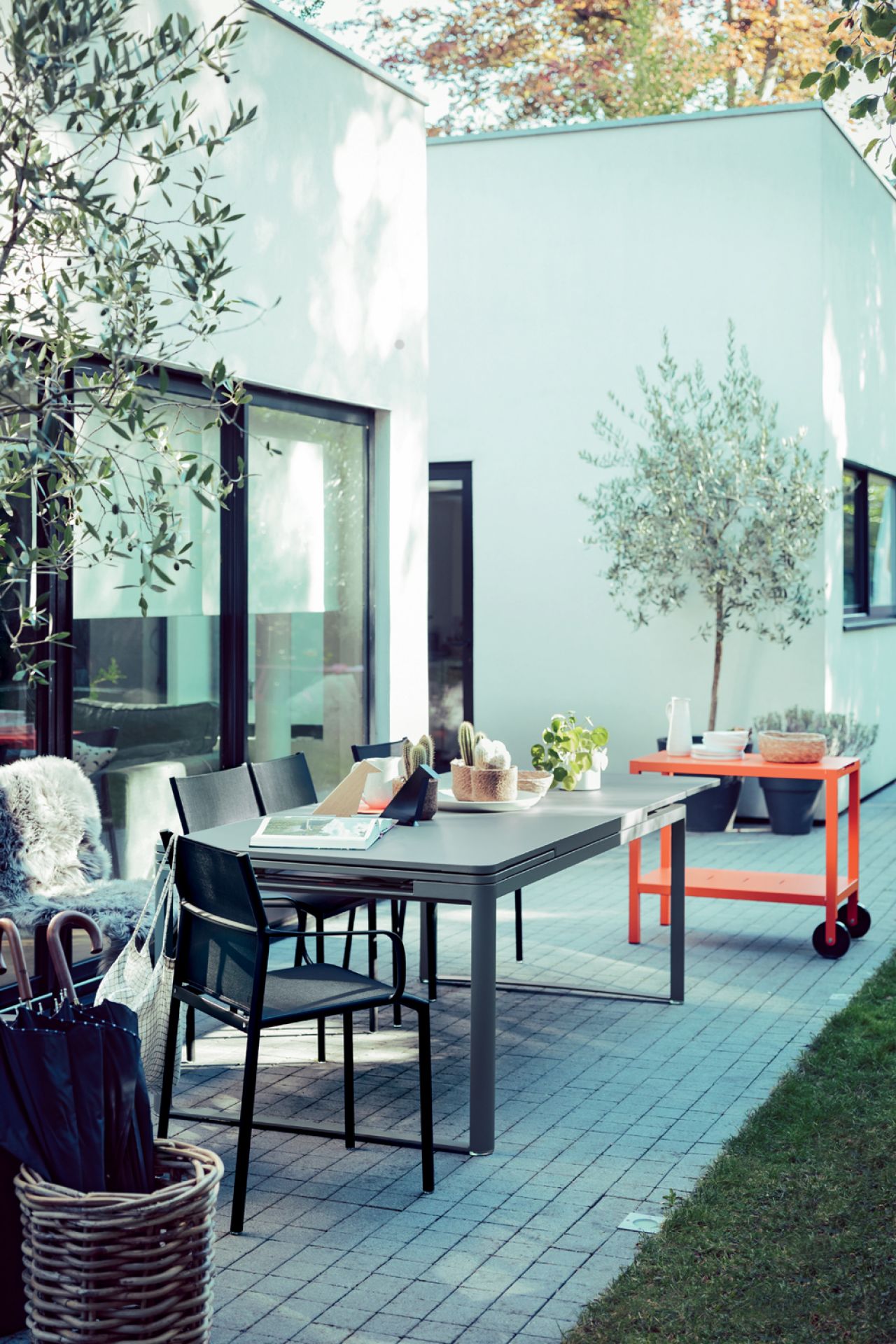 Cadiz Outdoor Chair von Fermob, schwarzer Gartenstuhl aus Metall mit Armlehne am Esstisch im Garten.