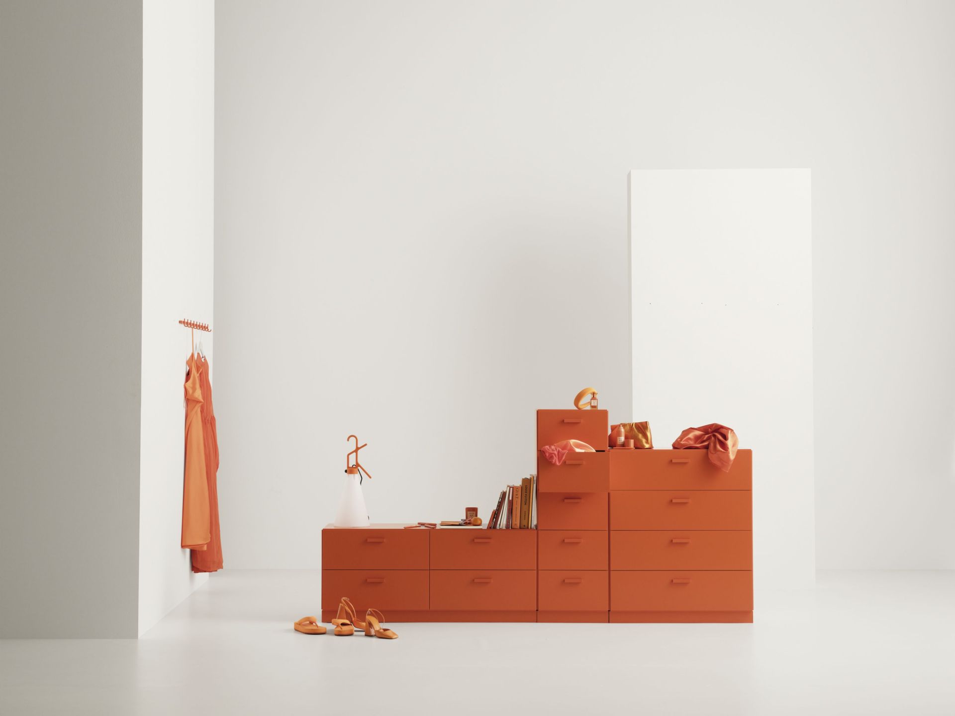 Orangefarbene Relief Kommode von String Furniture mit Esche Beinen in minimalistischem Raum.