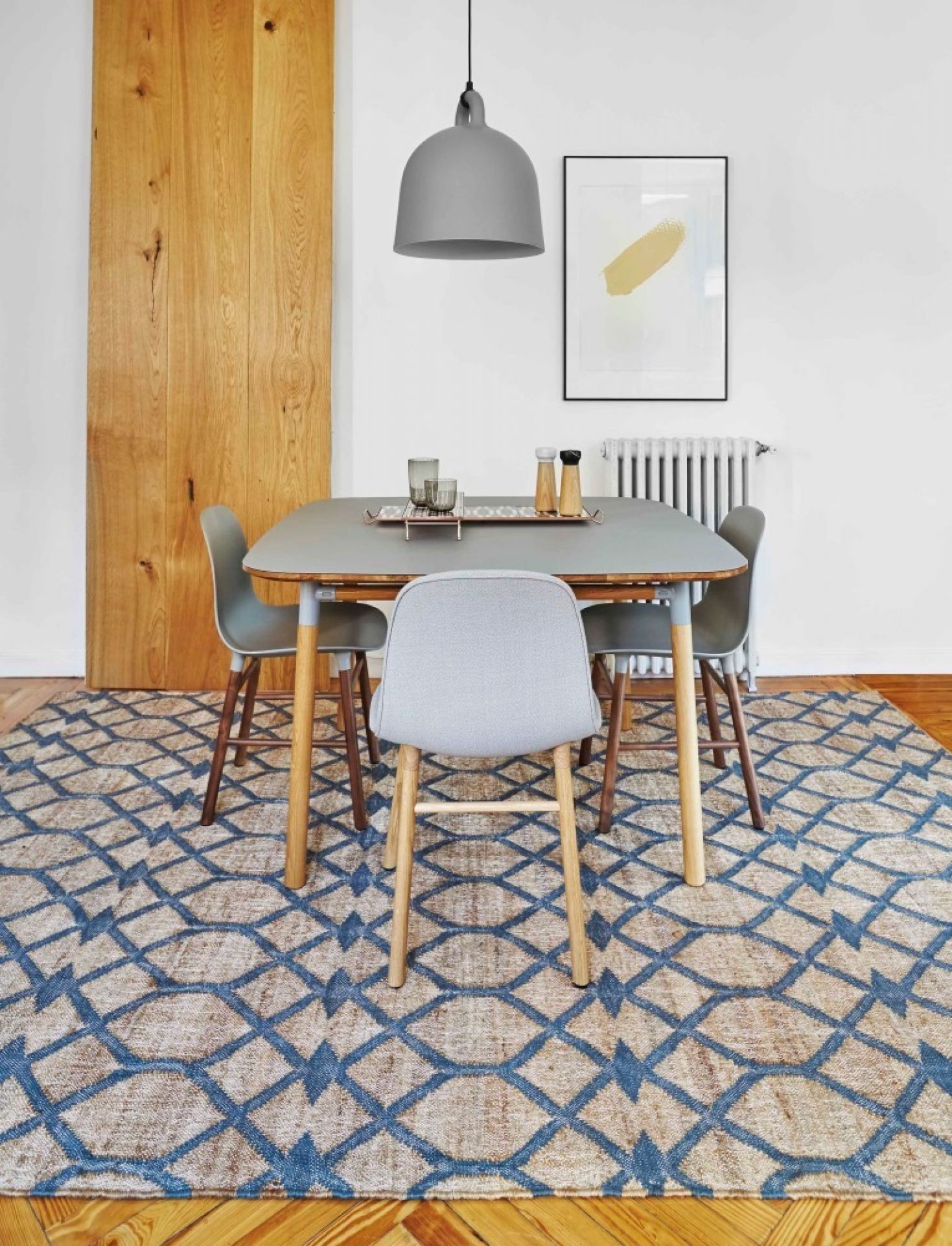 Detailaufnahme des GAN Kilim Rodas Teppichs 170x240 mit blauem geometrischen Muster unter einem Esstisch.