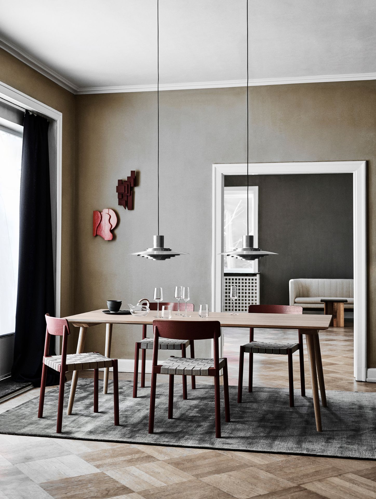 AndTradition P376 Pendelleuchte über Esstisch mit Stühlen, Teegeschirr und Dekoration in modernem Esszimmer.