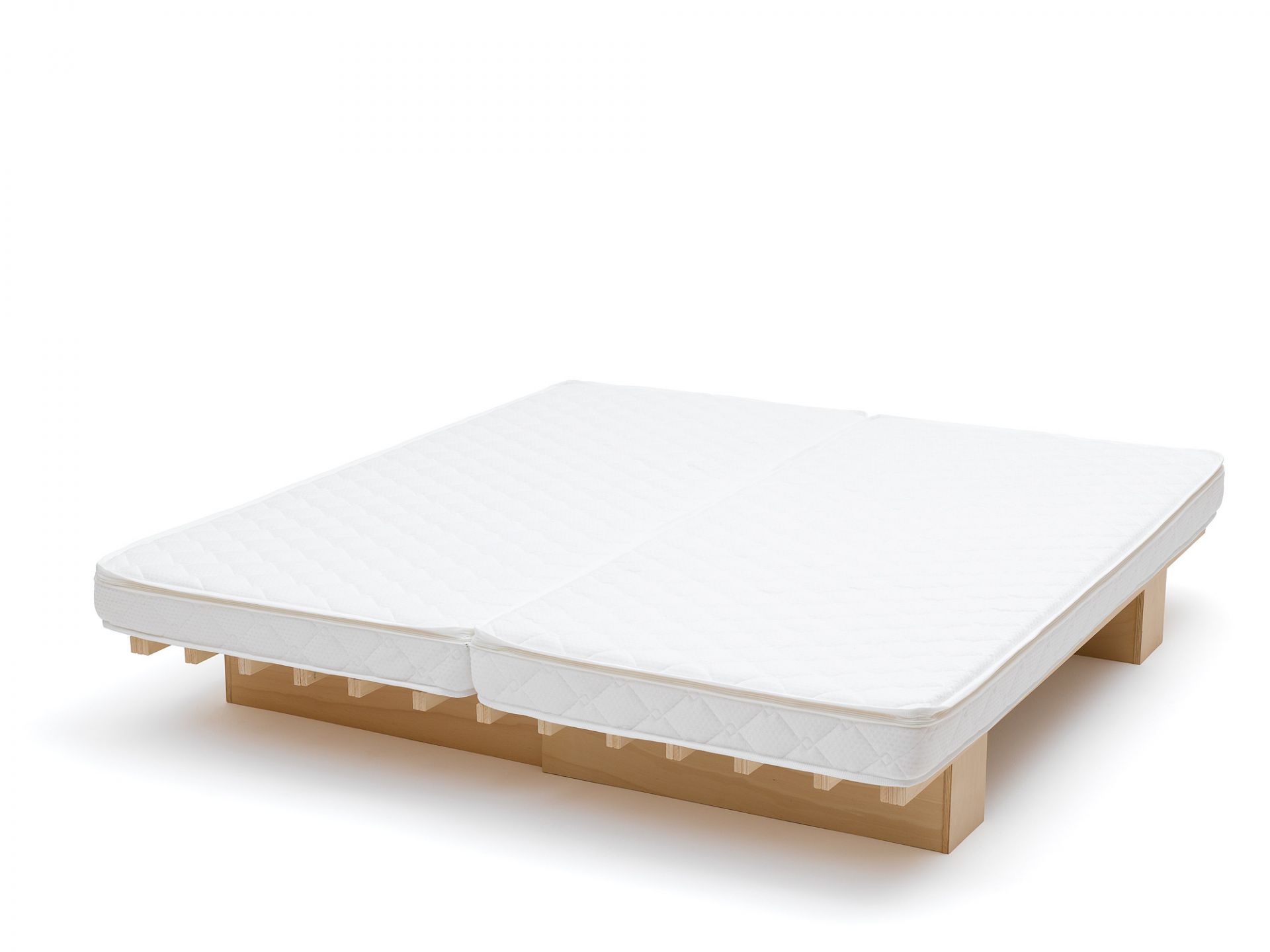 Weiße Ergo Faltmatratze von Tojo auf einem hellen Holzgestell, ideal für Gästezimmer und flexibles Wohnen.