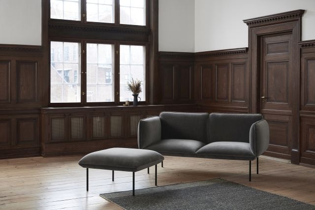 Rombo Rug Teppich in Weiß und Grau im Wohnzimmer unter einem grauen Sofa.