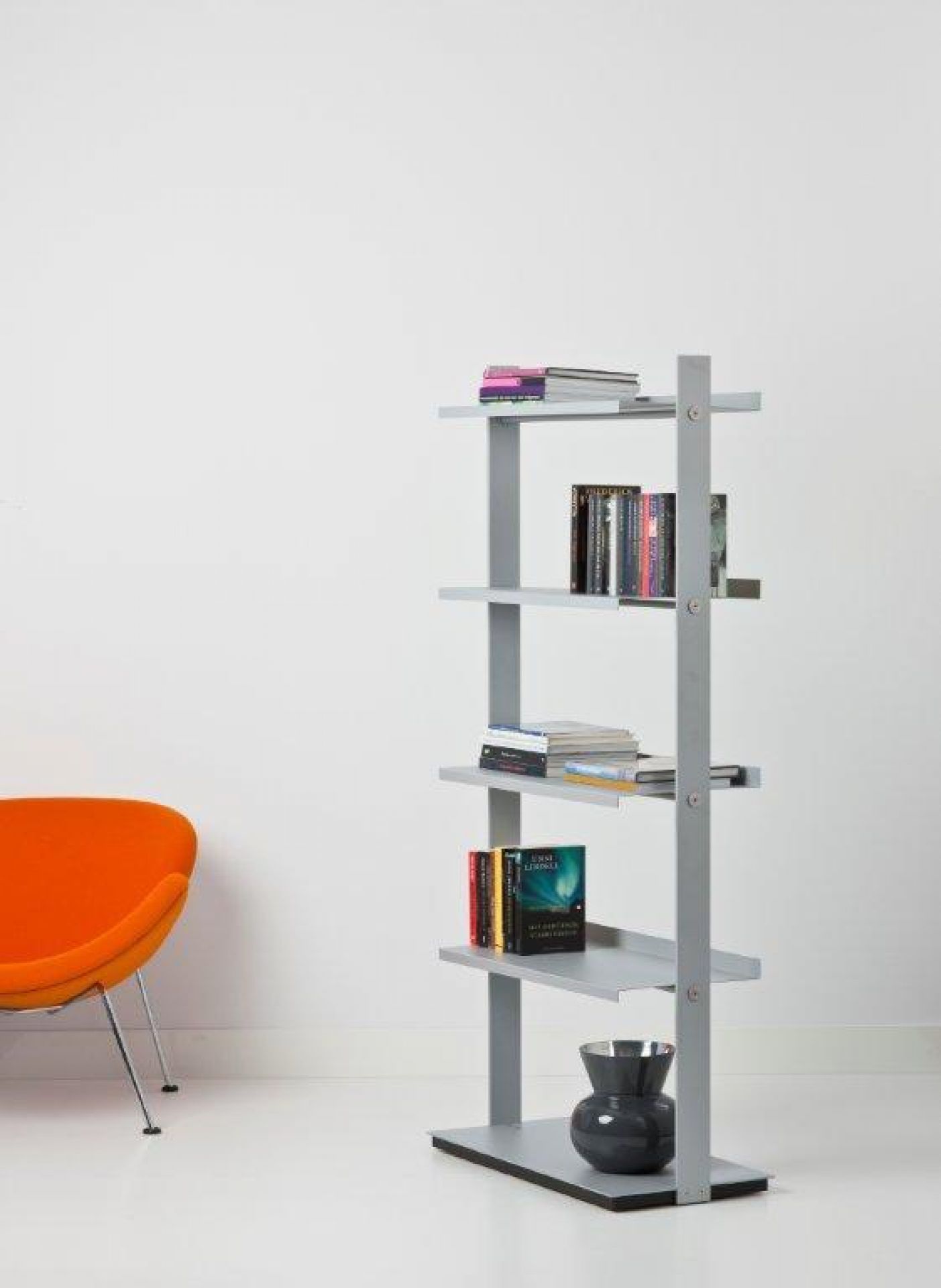 Graues Flexxible Regal / Prospektständer von Cascando mit Büchern und Vase in minimalistischem Raum.