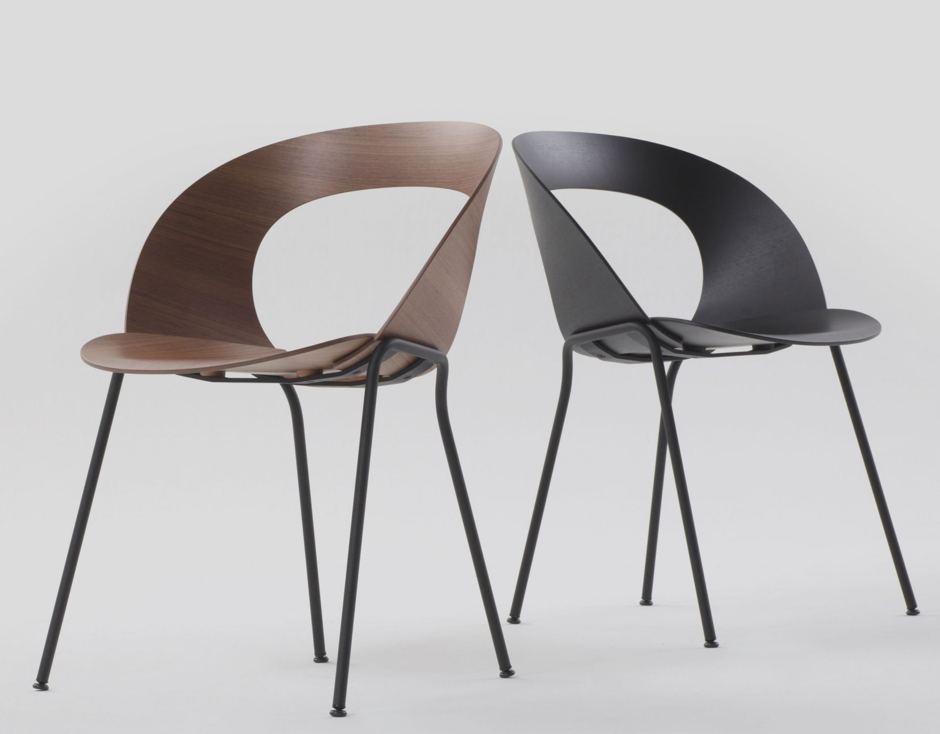 Zwei Brunner Mudra Stühle, einer aus Holz, einer schwarz, minimalistisches Design mit Stahlbeinen.