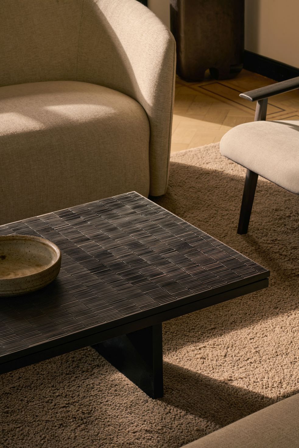 Grooves Couchtisch von Ethnicraft mit gerillter Oberfläche und Keramikschale im Wohnzimmer. Moderner Holztisch.