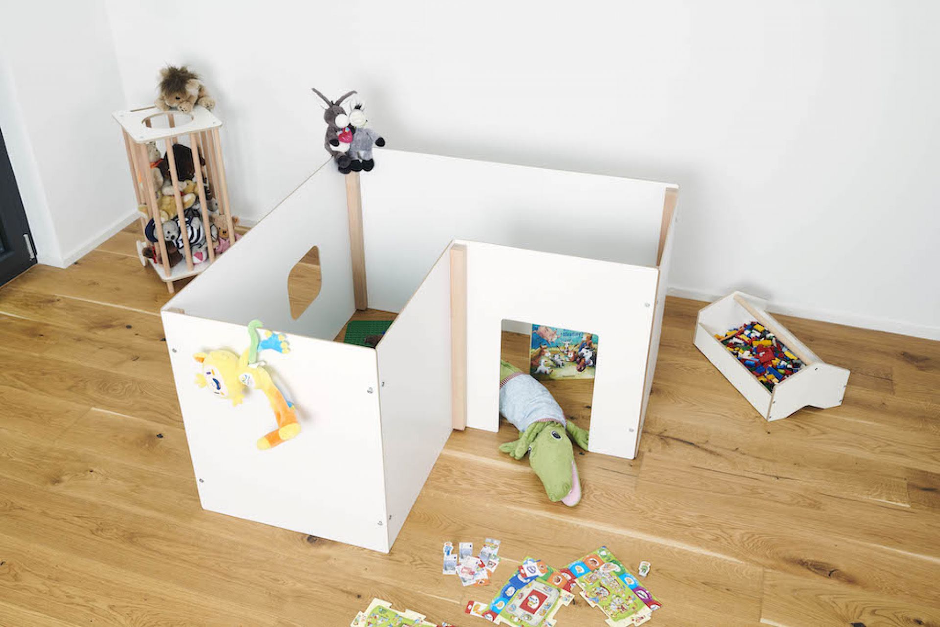 Tojo Kids Wand Spielewände: Weißes, modulares Spielhaus für Kinder mit Spielzeug auf Holzboden.