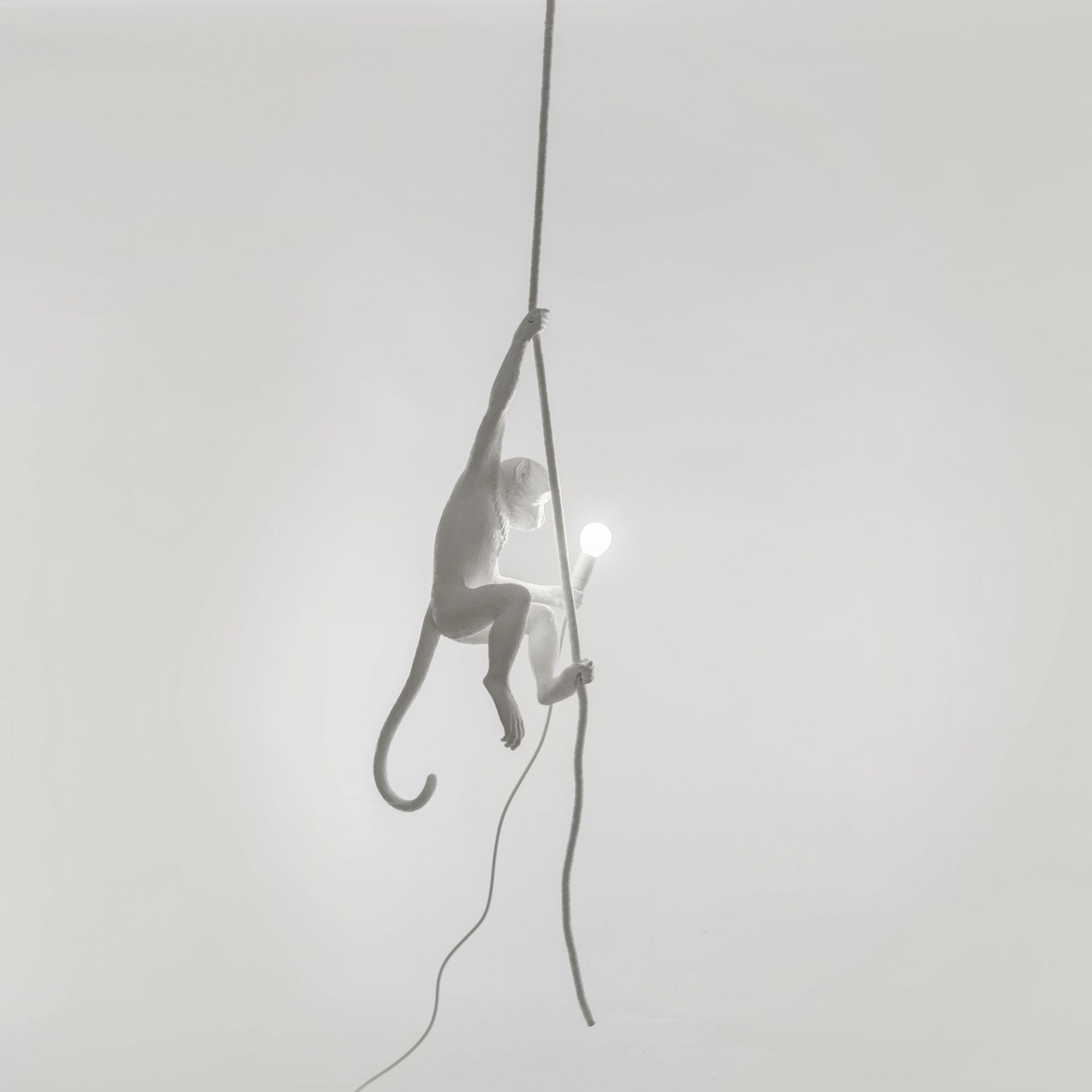 Weiße Monkey Lamp Pendelleuchte von Seletti, ein Affe hält eine Glühbirne an einem Seil.