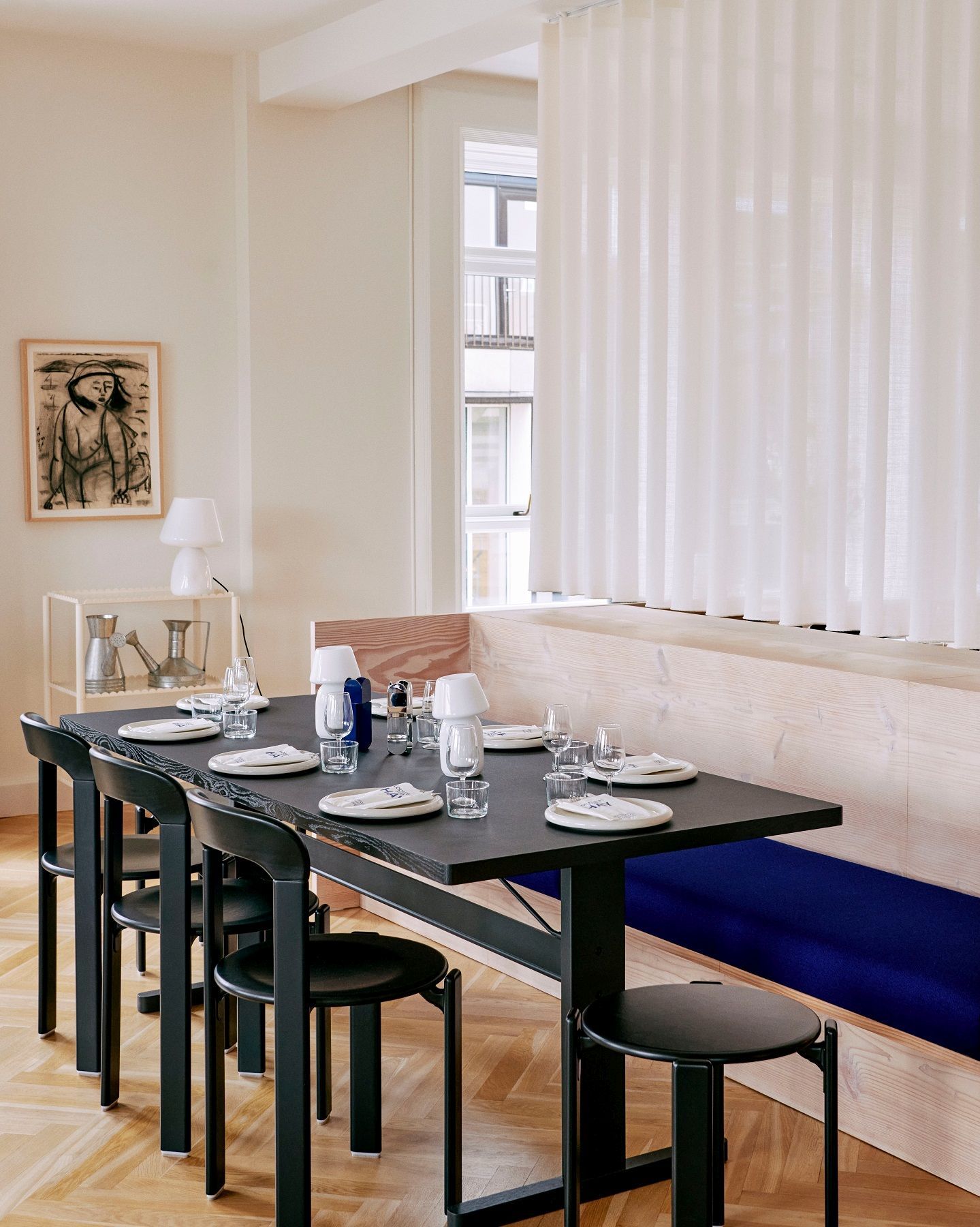 Esstisch mit schwarzen Rey Stool Hockern von Hay in modernem Esszimmer mit Geschirr und Dekoration.
