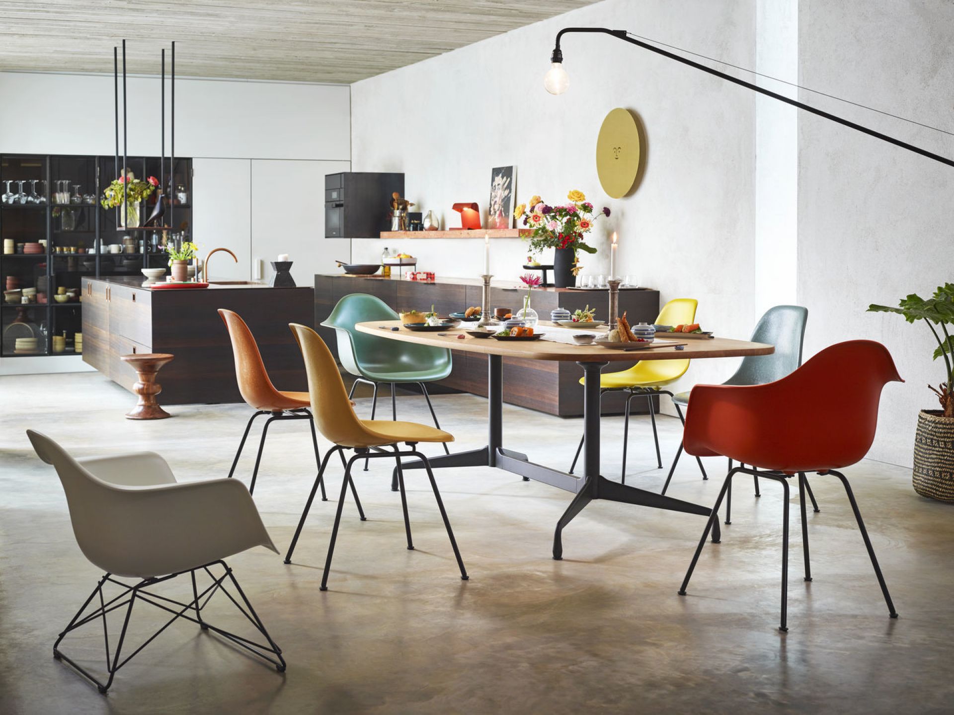 Esszimmer mit Esstisch und mehreren bunten Eames Fiberglass Arm Chairs LAR Stühlen von Vitra.