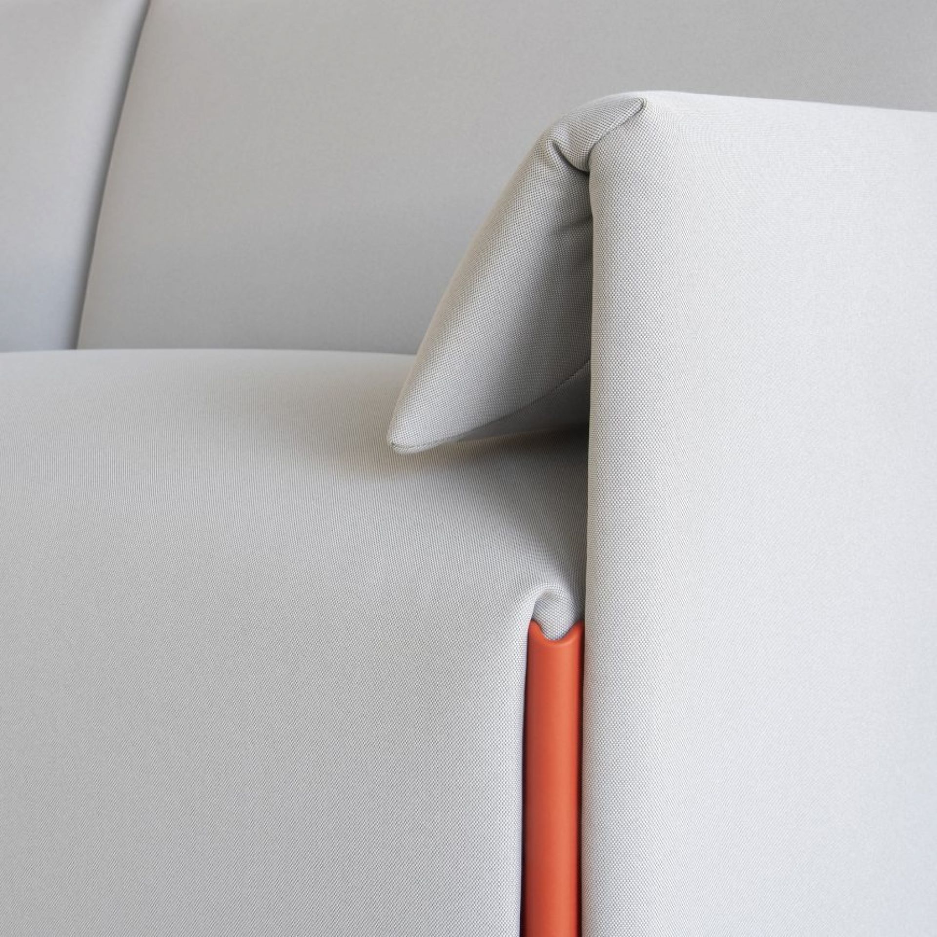 Detailaufnahme: Costume Modulsofa mit Armlehne links und orangefarbenem Detail. Modernes Sofa für Wohnzimmer.
