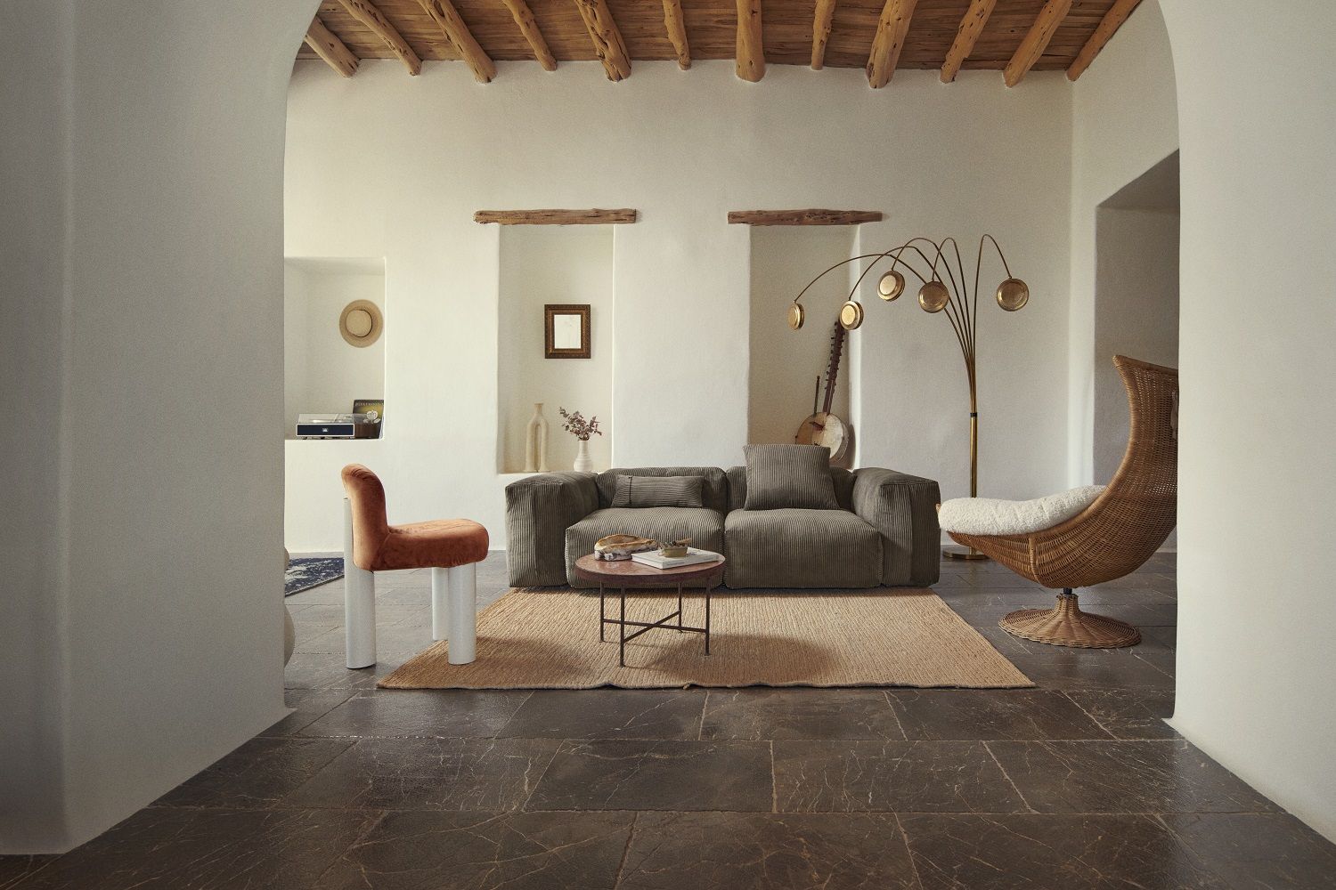 Gemütliches Wohnzimmer mit vetsak Sofa Set, braunem Cord, Teppich, Sessel und Stehlampe.
