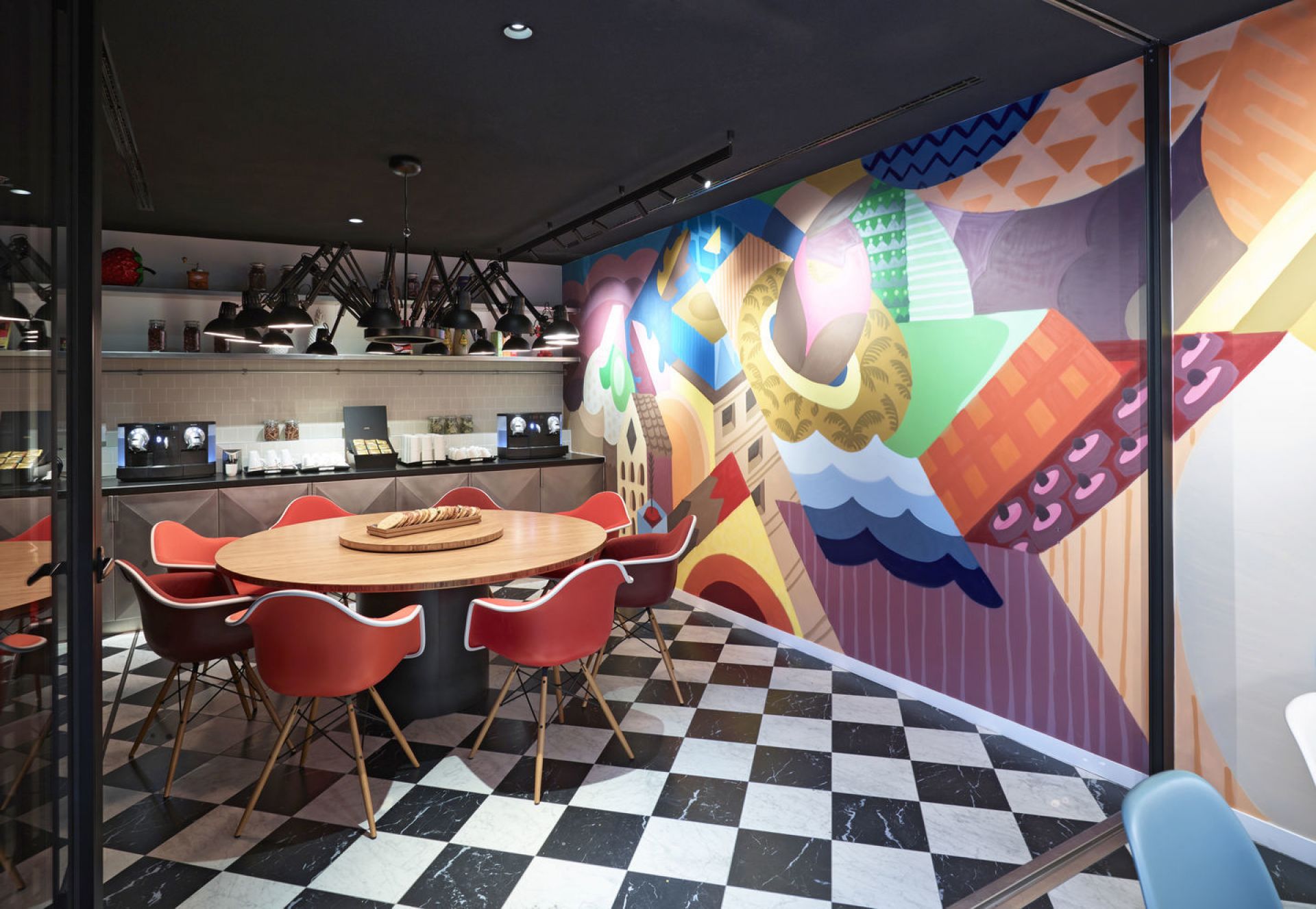 Roter Eames DAW Stuhl von Vitra, vollgepolstert, mit Holzbeinen um einen runden Tisch.