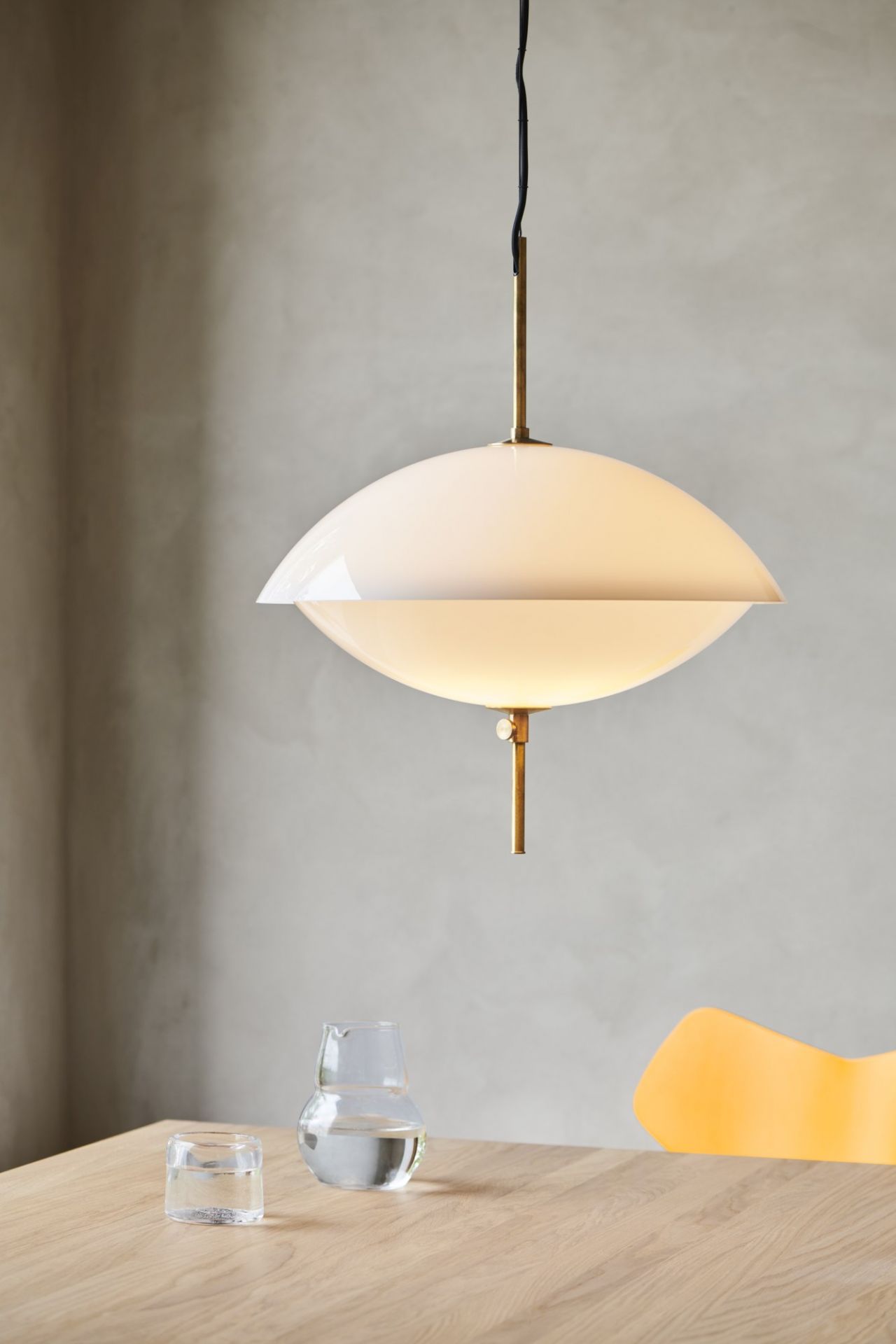 Nahaufnahme der Clam Pendelleuchte von Fritz Hansen, weiße Hängelampe mit Messingdetails.