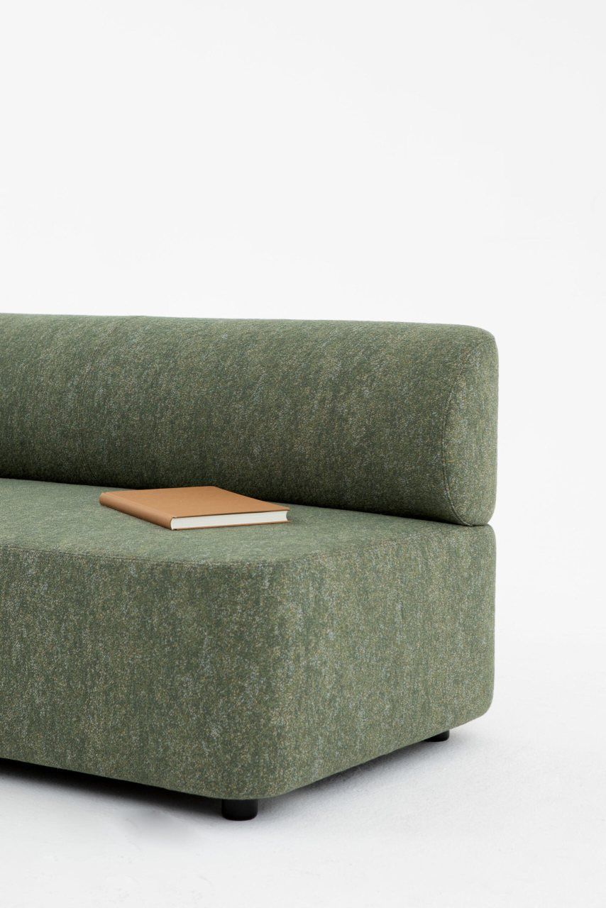 Mezza Sitzelement mit Rückenlehne von Cascando, modernes grünes Sofa mit Buch im Detail.