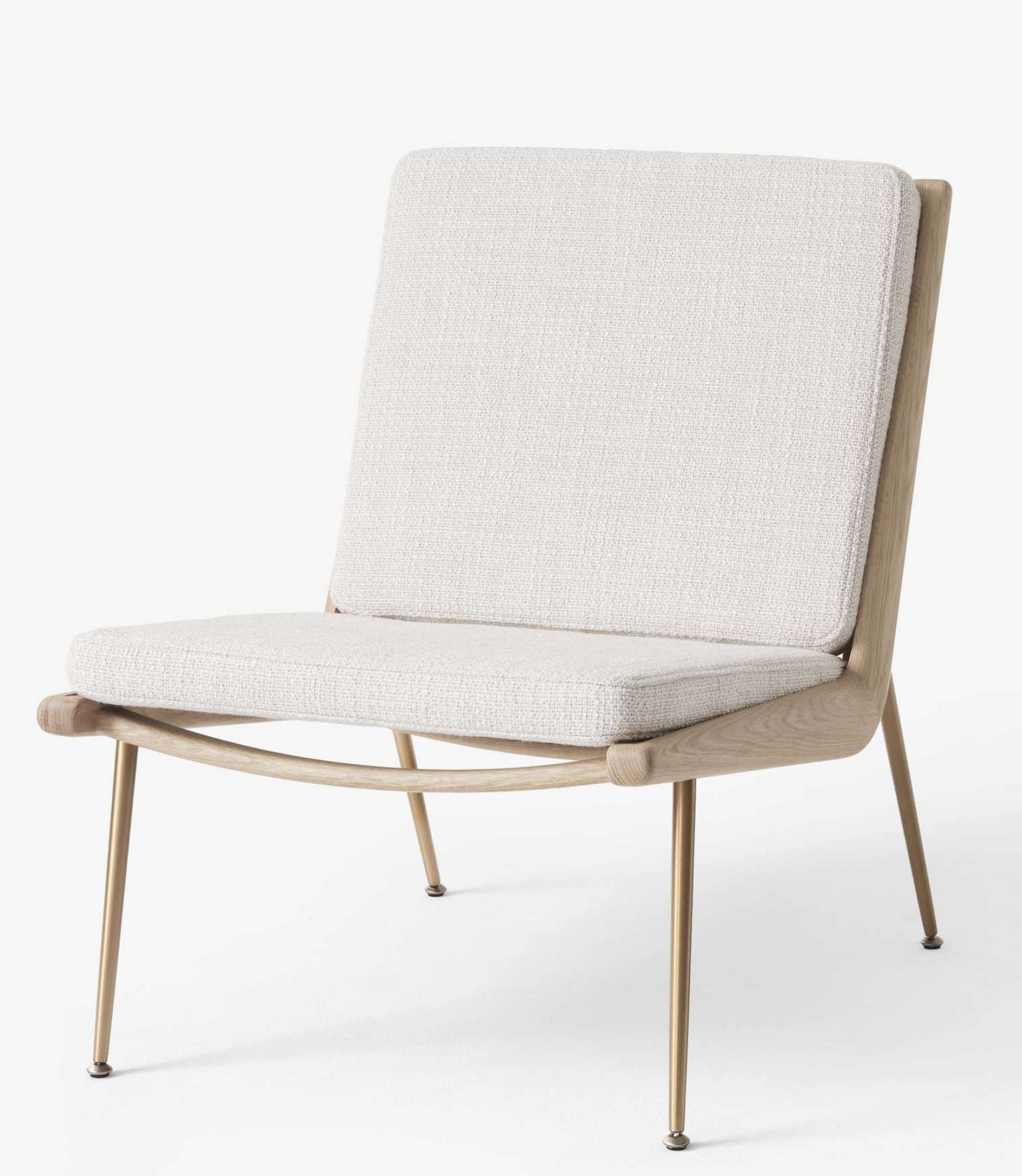 AndTradition Boomerang Lounge Chair HM1 Sessel mit hellem Stoffbezug und filigranem Holzgestell auf goldenen Füßen.