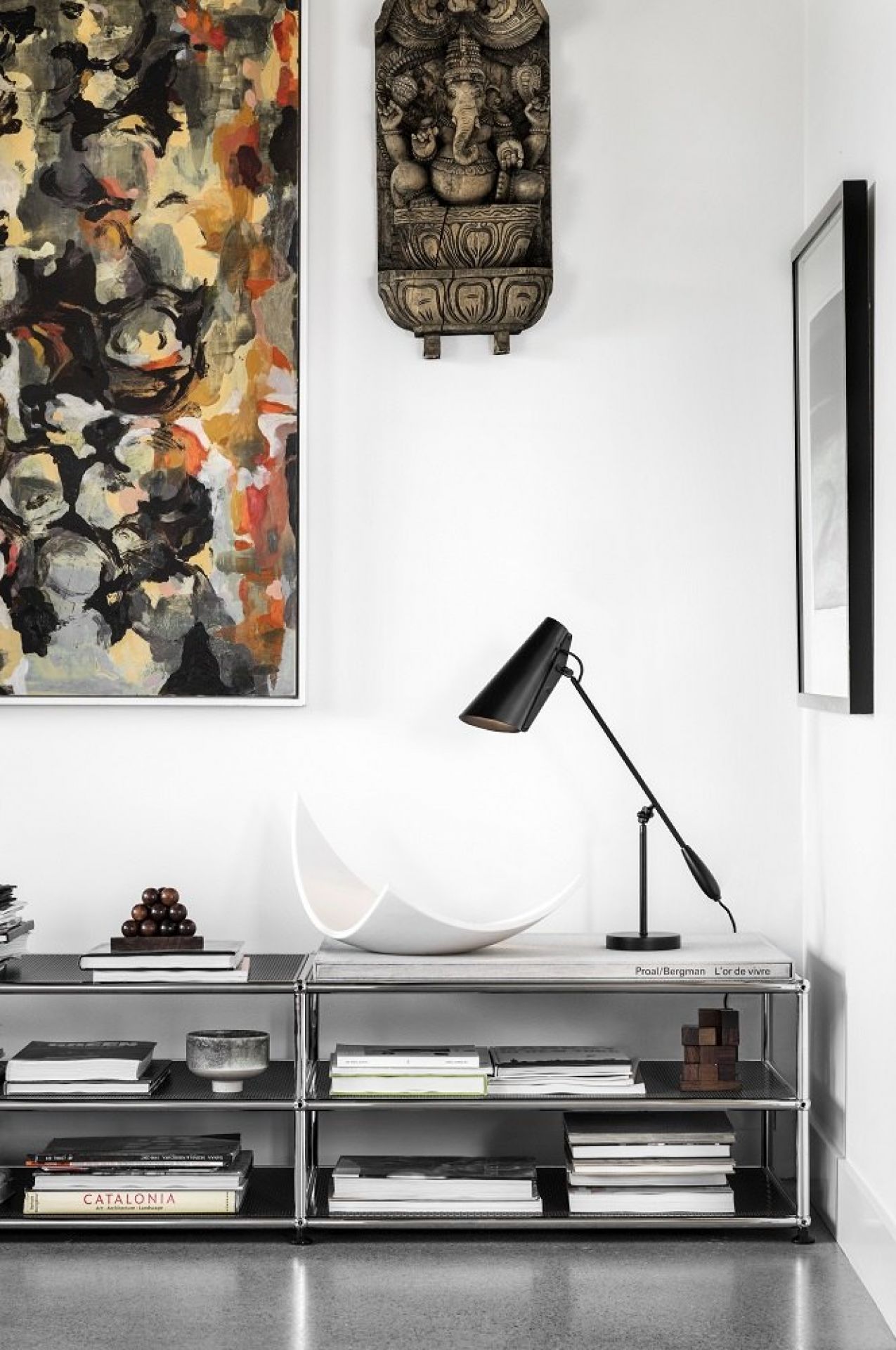 Schwarze Birdy Tischleuchte von Northern auf einem Regal mit Büchern und Dekoration, modernes Design.