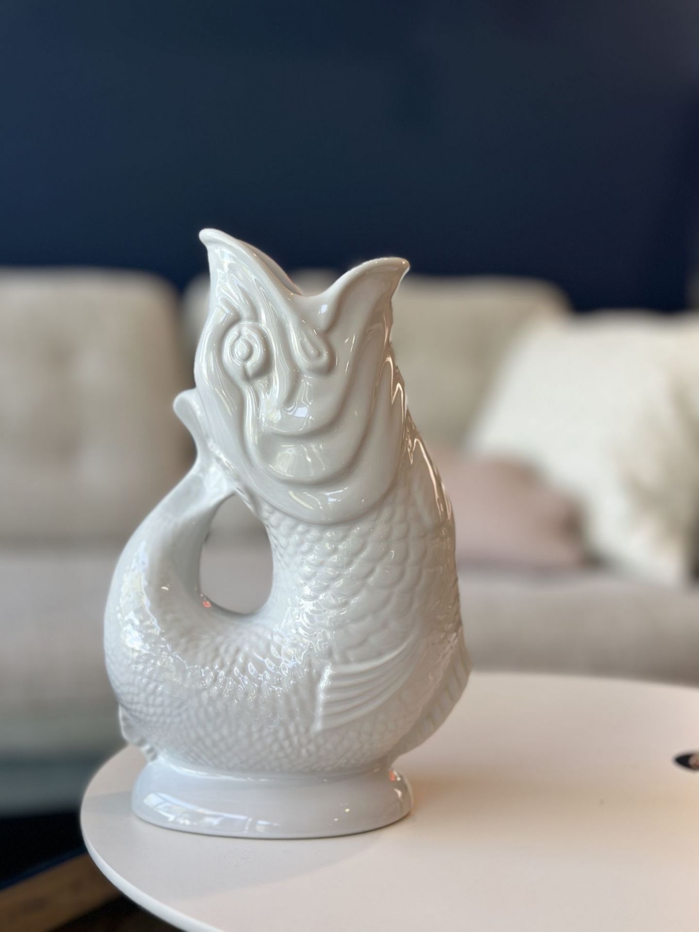 Weiße Gluckigluck Fischkaraffe XL auf einem Tisch, dekorative Keramikvase im Fischdesign.