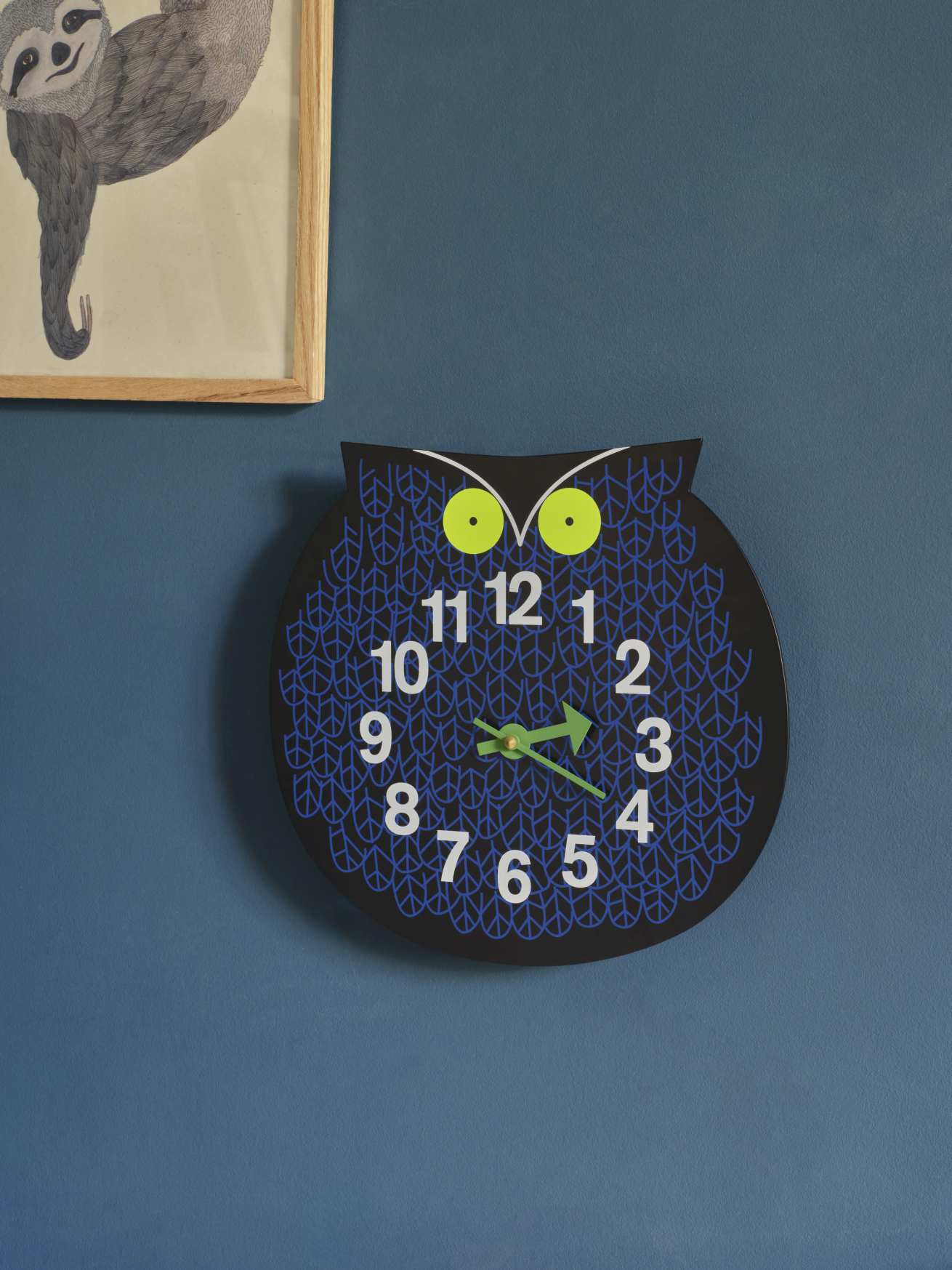 Nahaufnahme der Omar the Owl Wanduhr von Vitra, eine dekorative Eulen-Uhr mit blauen Mustern.