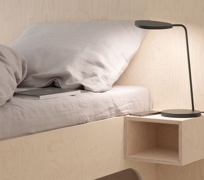 Nahaufnahme eines schwarzen VALENTINA Bettes (180x200 cm) mit Nachttisch, Lampe und Buch. Schlafzimmer-Möbel für erholsamen Schlaf.