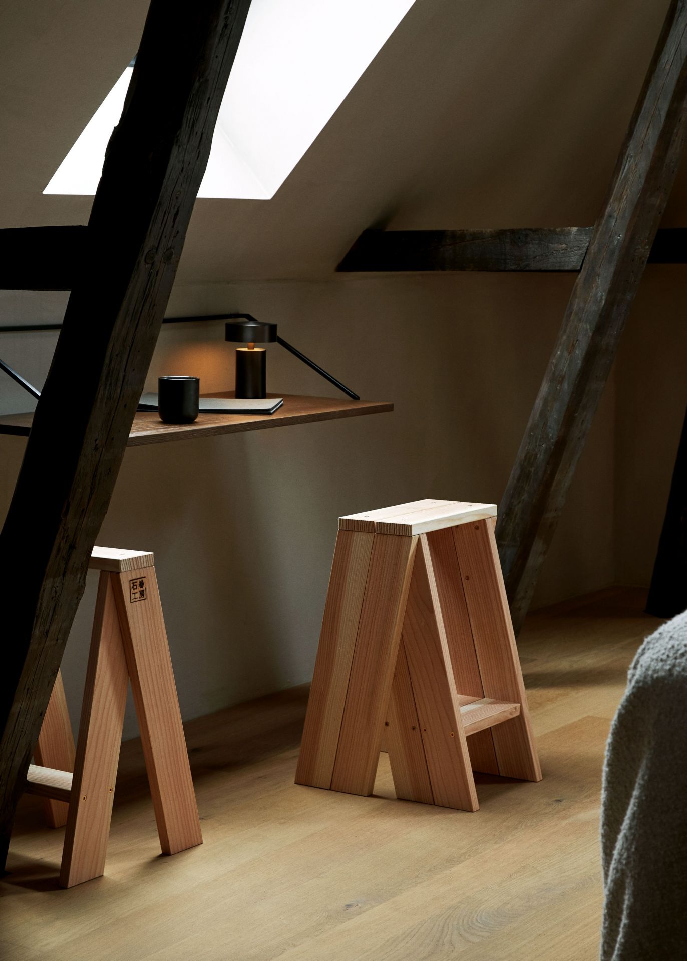 Column Tischleuchte von Audo auf einem Schreibtisch in einem Dachzimmer mit Holzstühlen.