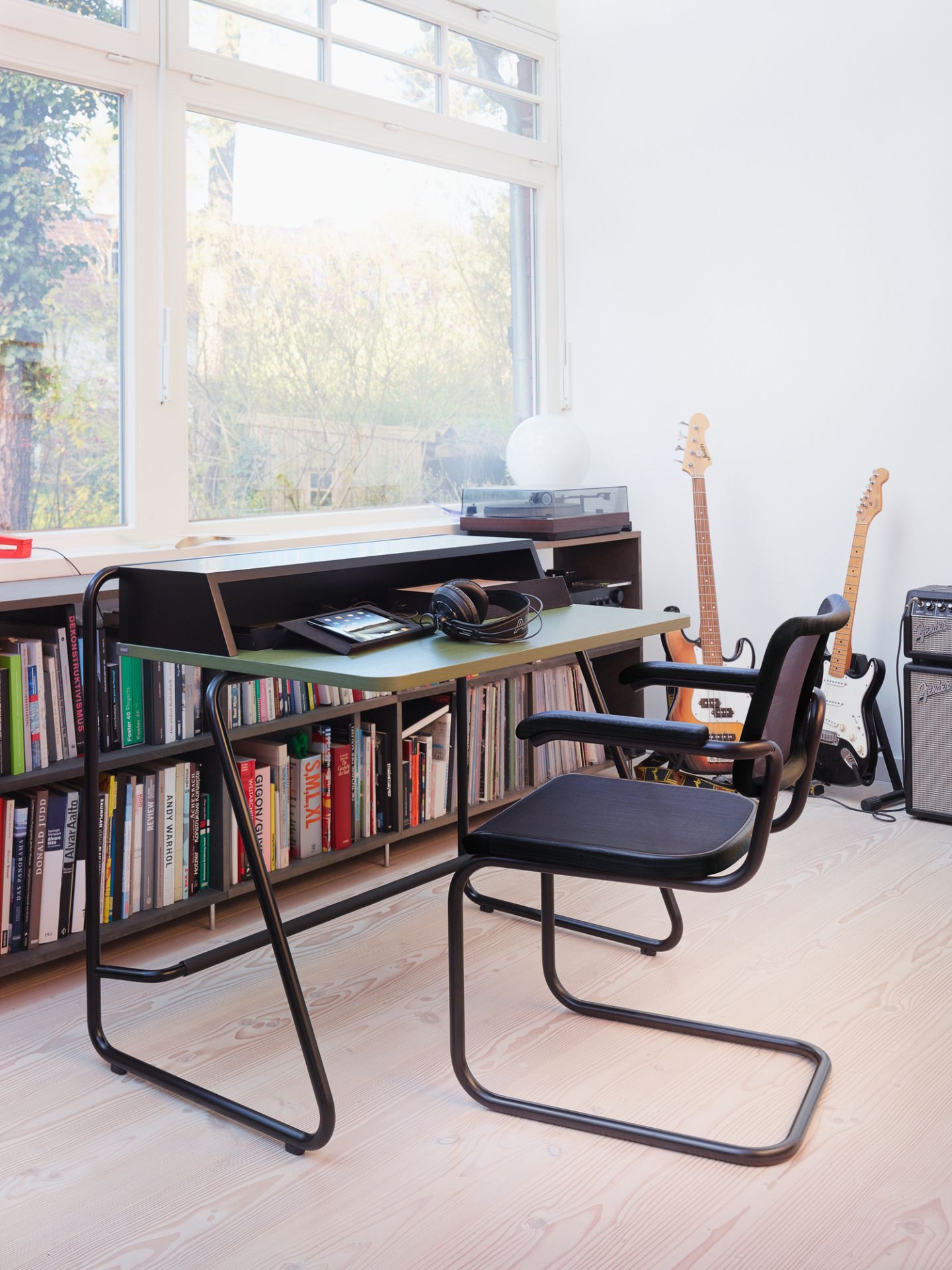 Thonet S 1200 Sekretär mit Regal, Schreibtischstuhl und Musikinstrumenten vor Fenster für modernes Wohnen.