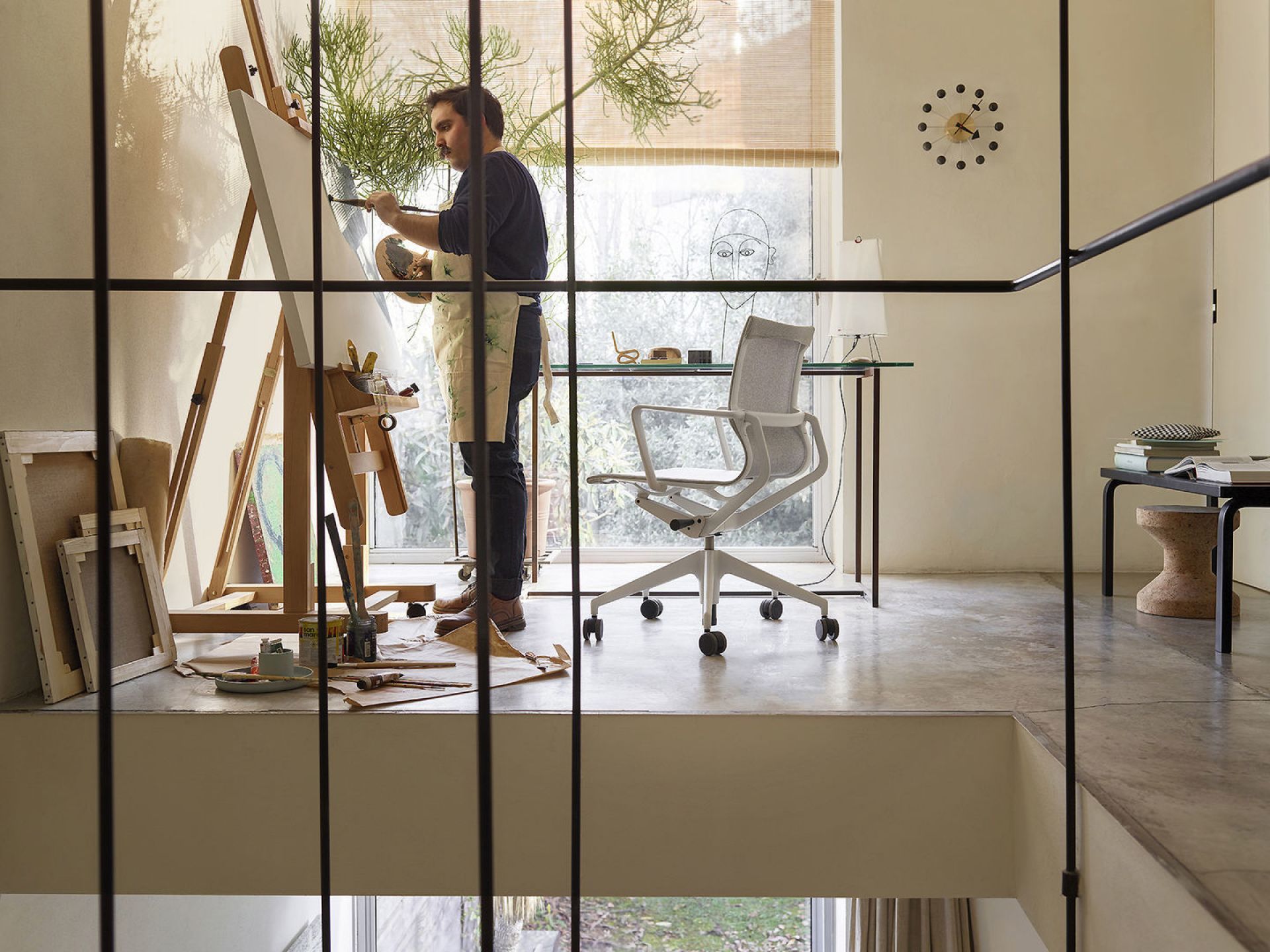 Vitra Physix Bürostuhl in hellem Arbeitszimmer mit Künstler beim Malen auf Staffelei.