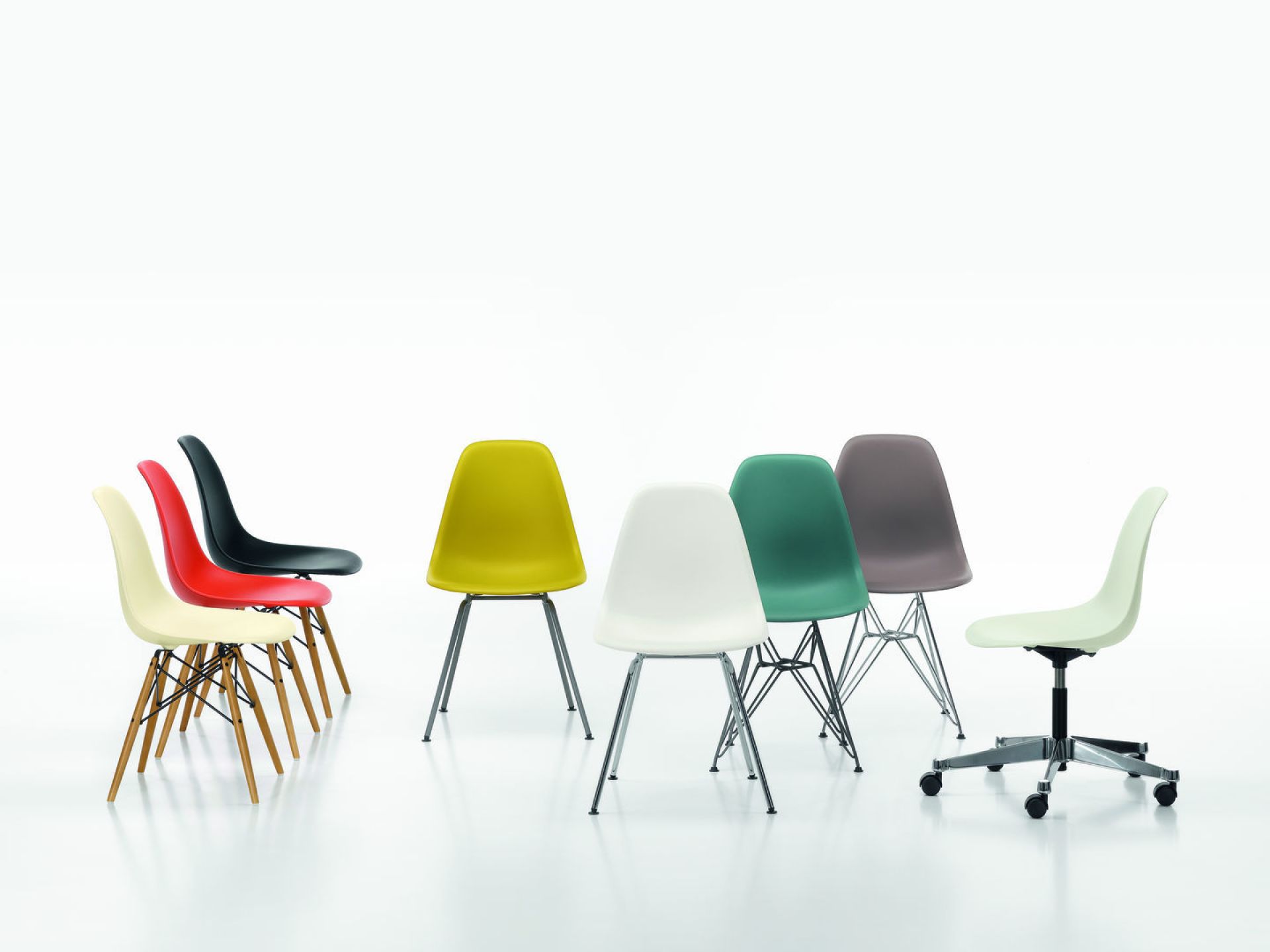 Mehrere Vitra Eames Plastic Chairs in verschiedenen Farben und Gestellen, darunter ein Drehstuhl.