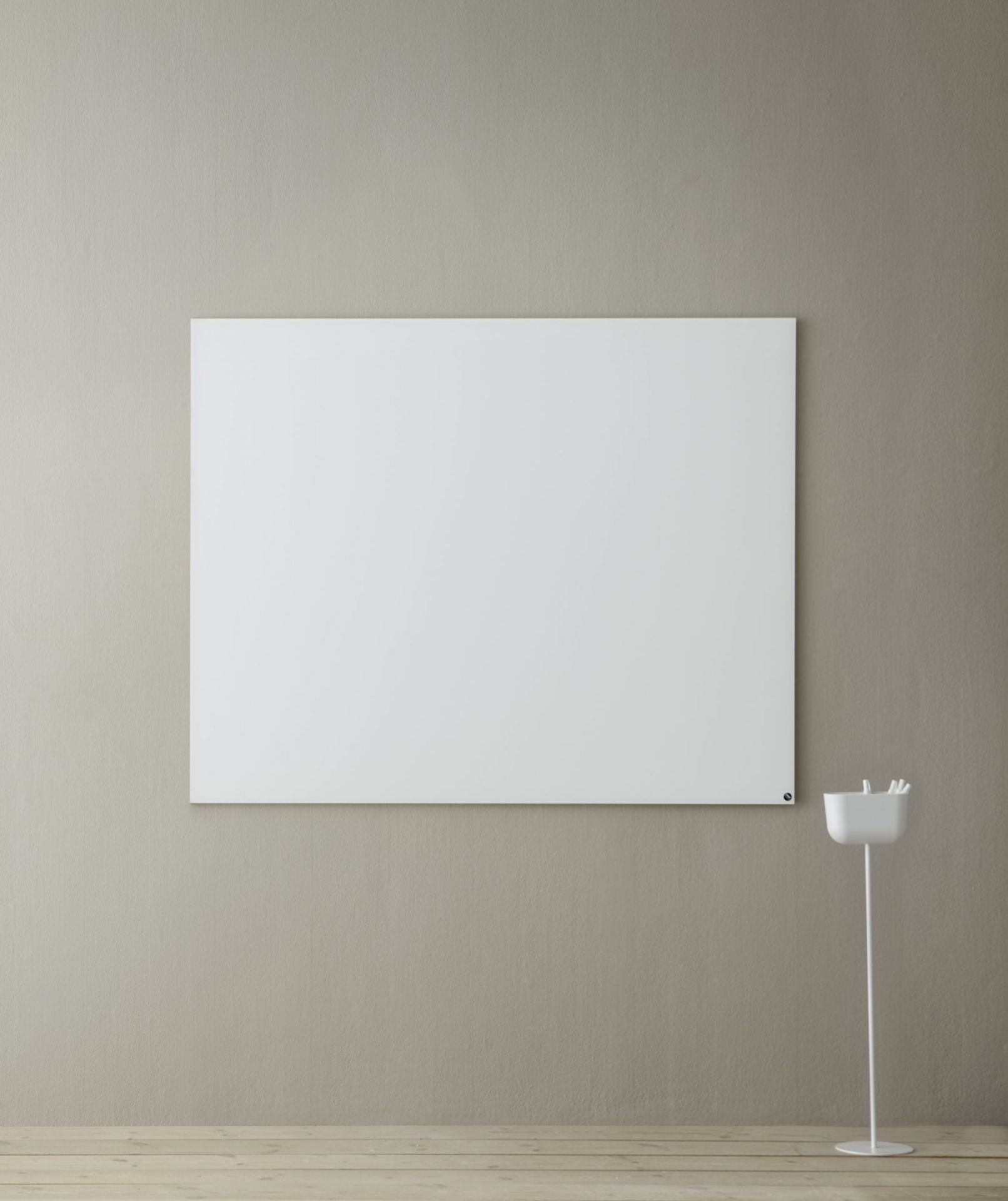 Weiße Chat Board Elements magnetische Glastafel an einer Wand, daneben ein Stifthalter.