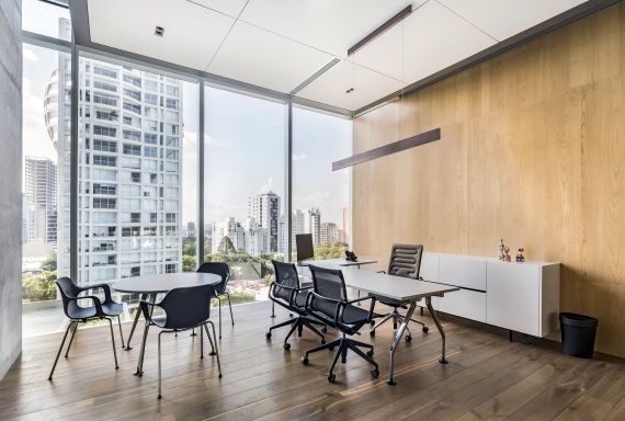 Hal RE Armchair von Vitra: Stapelbarer Armlehnenstuhl in einem modernen Büro mit Stadtblick.