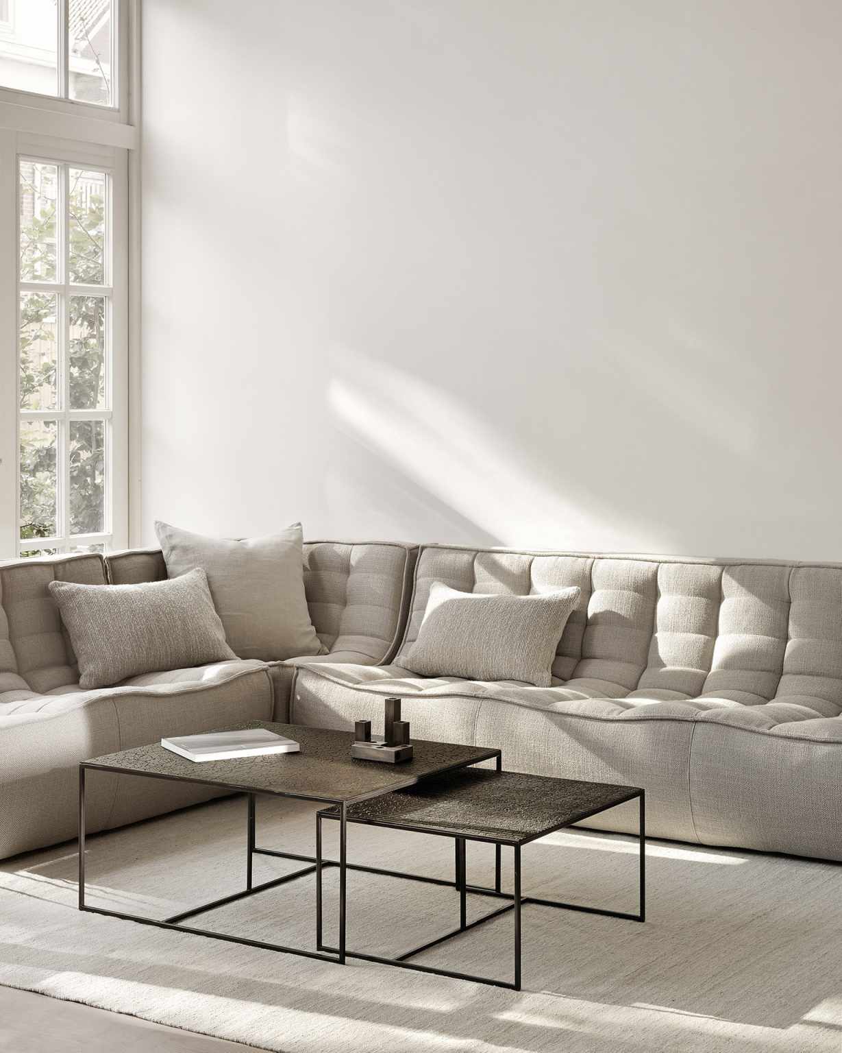 Wohnzimmer-Szene mit beigem Sofa und Ethnicraft Kissen. Dekokissen in Oliv-Tönen für gemütliches Wohnen.
