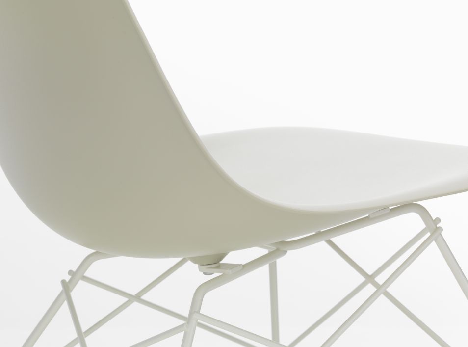 Detailaufnahme von einem weißen Eames Plastic Side Chair LSR Stuhl von Vitra mit verchromtem Drahtgestell.