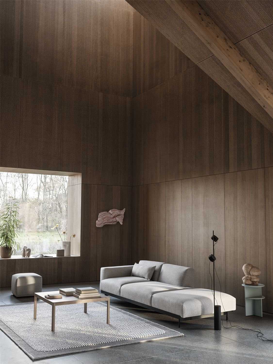 Heller Raum mit Sofa, Teppich und Echo Pouf Hocker von Muuto in Grau.
