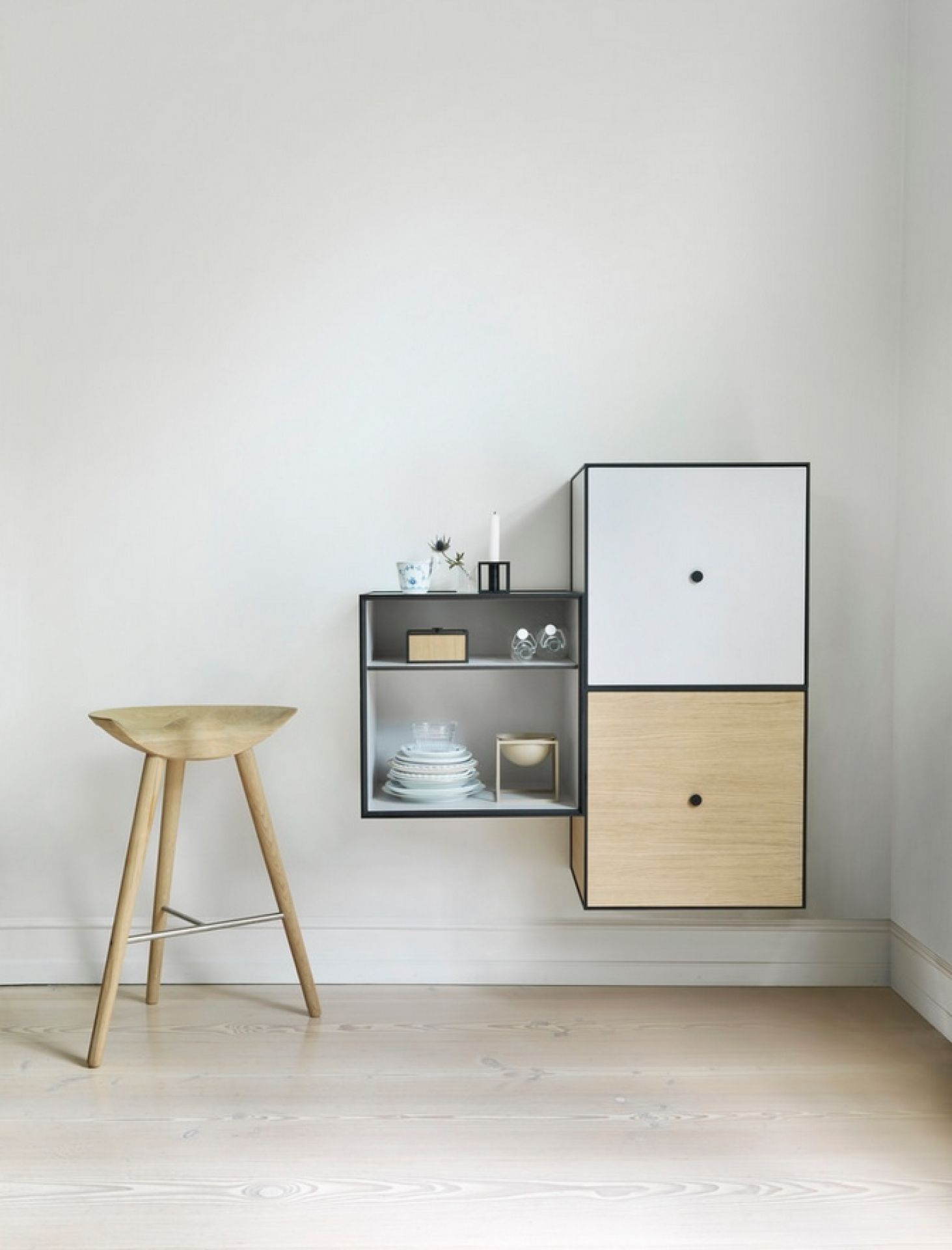 Audo ML42 Thekenhocker aus hellem Holz vor weißer Wand mit Regal im minimalistischen Design.