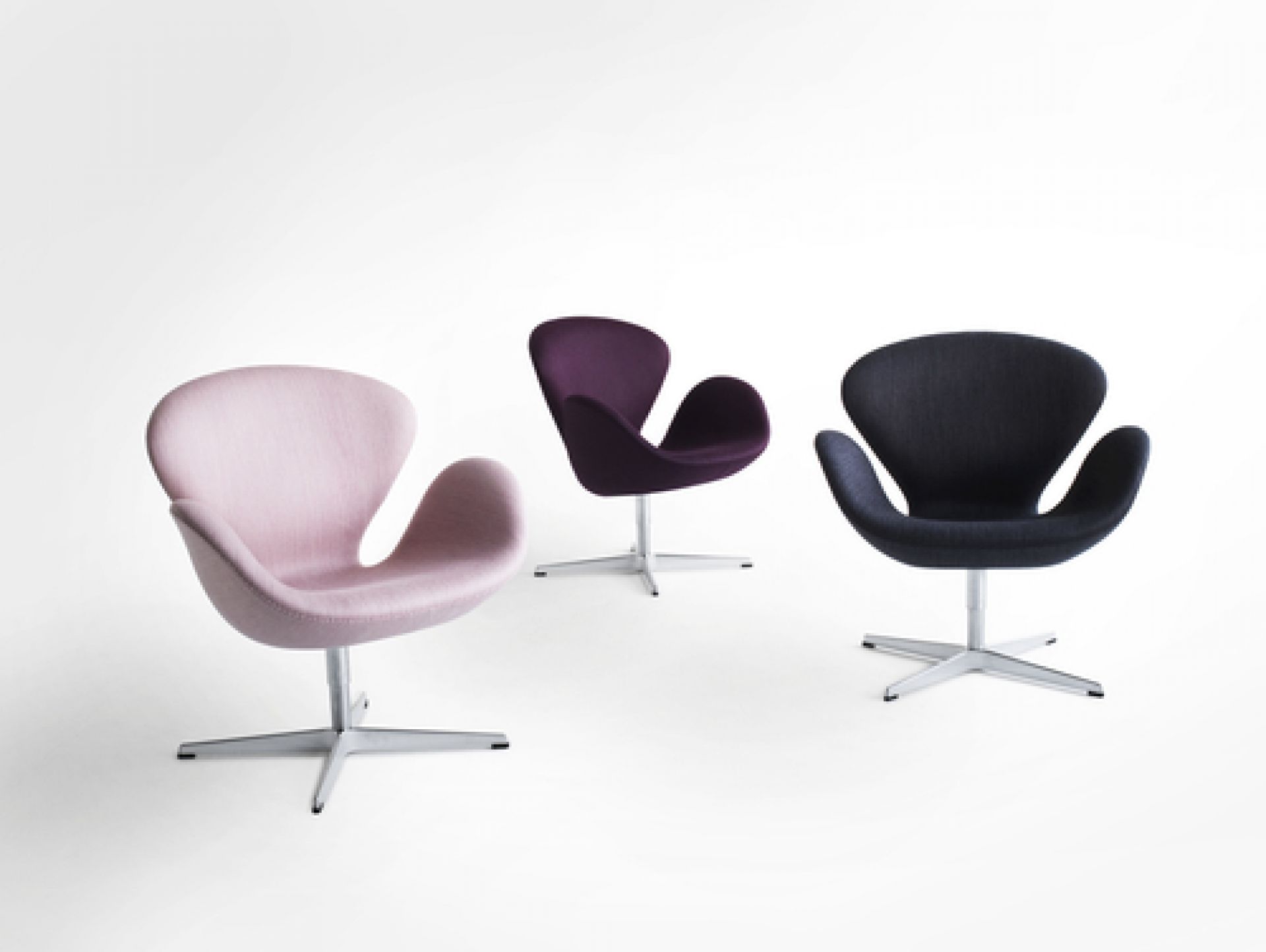 Drei Fritz Hansen Schwan Sessel in Rosa, Lila und Dunkelblau auf einem weißen Hintergrund.
