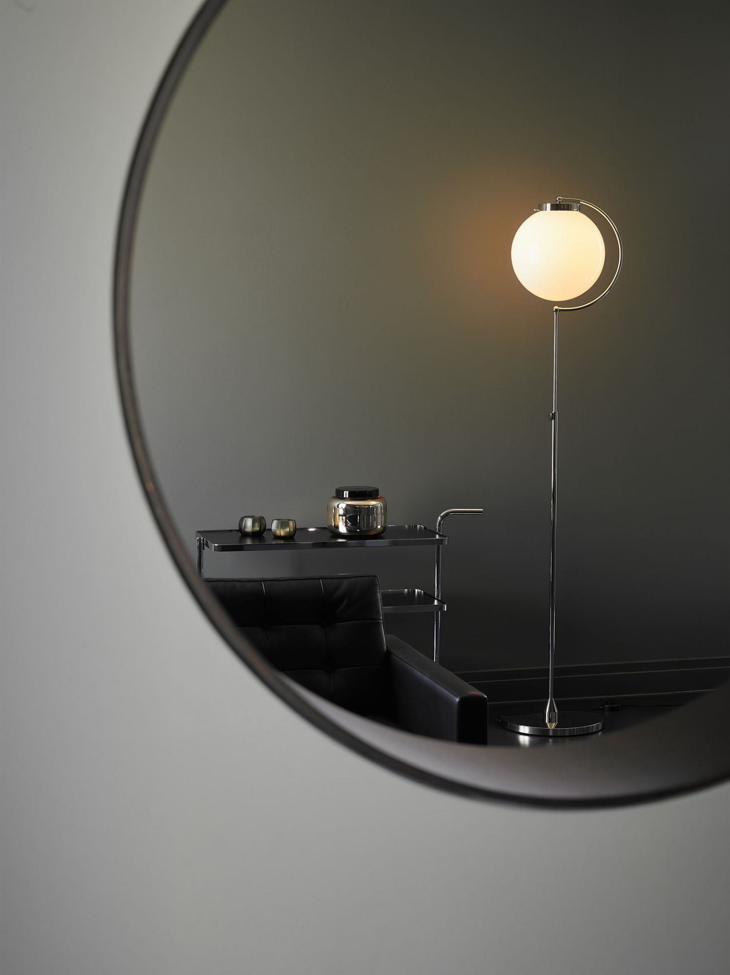 Nahaufnahme der Bauhaus DSL 23 Stehleuchte Tecnolumen mit runder, leuchtender Glaskugel.