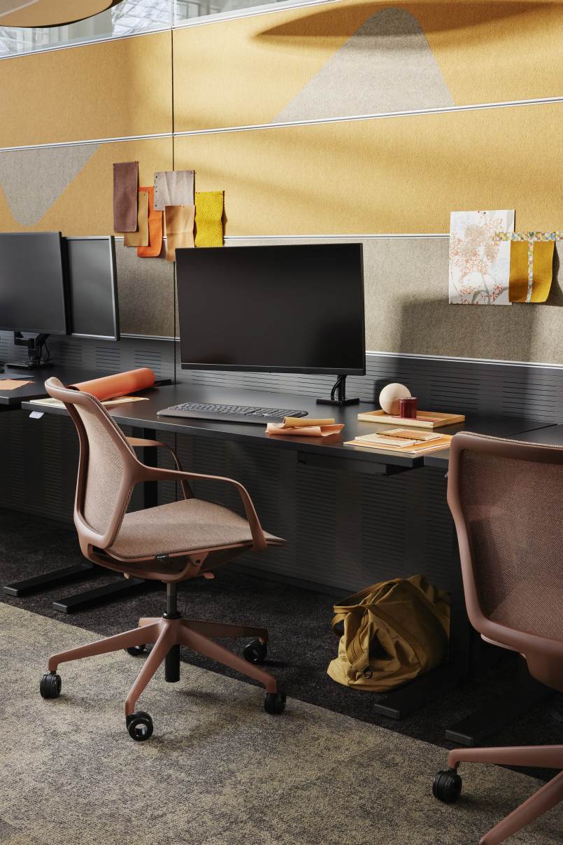 Ray Work 9220 Bürodrehstuhl von Brunner in Braun vor einem modernen Büroarbeitsplatz mit Computern.