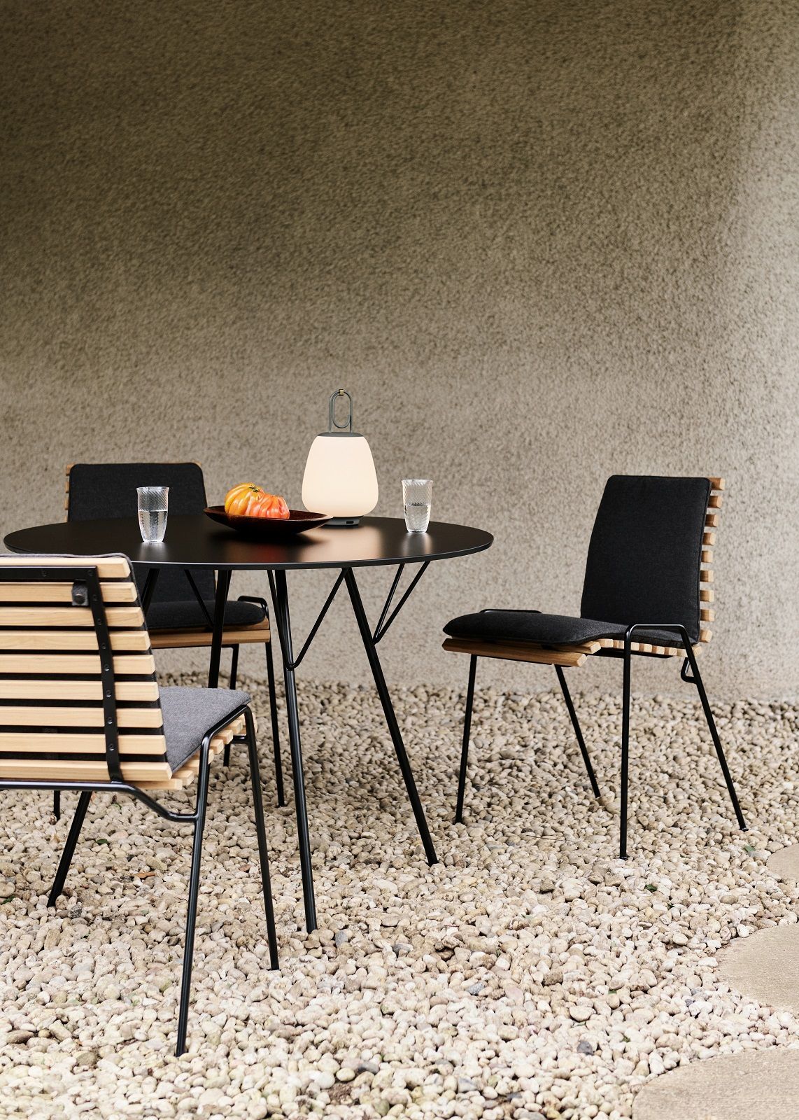 RFH Robin Day Esstisch mit Stühlen im Außenbereich, modernes Design, schwarzes Metallgestell, Holzelemente.