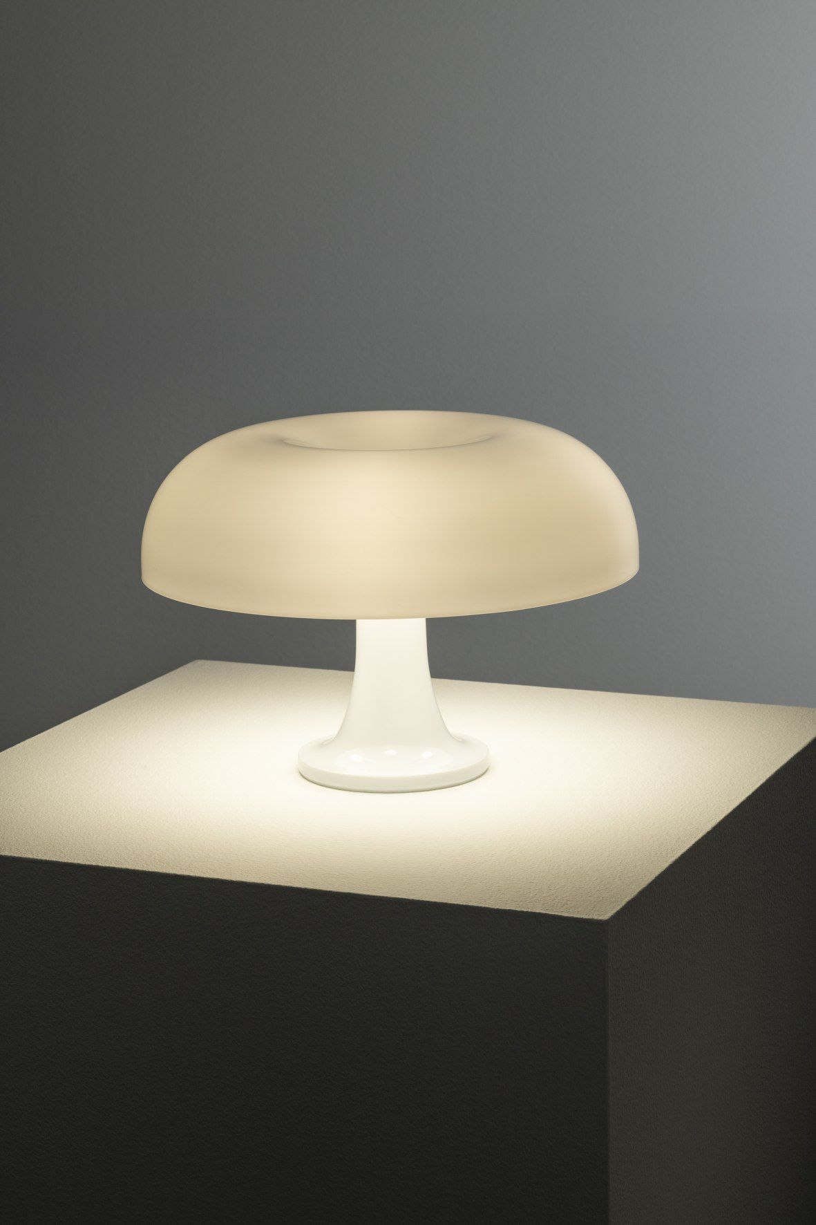 Weiße Nessino Tischleuchte von Artemide mit pilzförmigem Lampenschirm spendet warmes Licht. Designklassiker für Wohnzimmer und Schlafzimmer.
