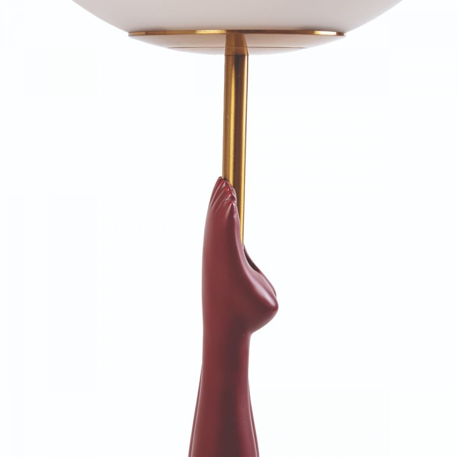 Detailaufnahme der Seletti Diver Tischleuchte in Gelb mit Hand-Design und goldenem Akzent.