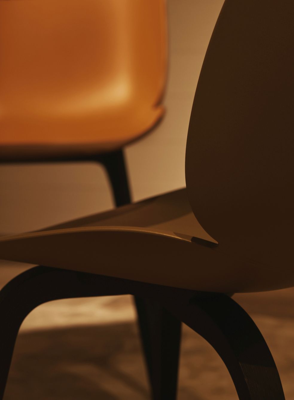 Detailaufnahme: Ungepolsterter Beetle Chair Esszimmerstuhl von Gubi in Alabaster White mit dunklem Gestell.
