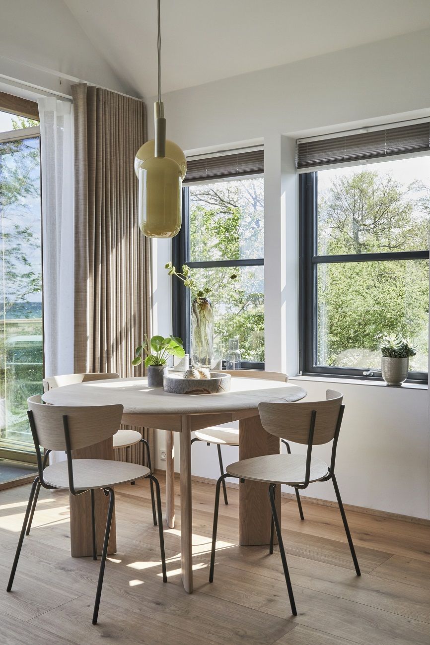 Esszimmer mit rundem Holztisch und vier Herman Chair Stühlen von Ferm Living.